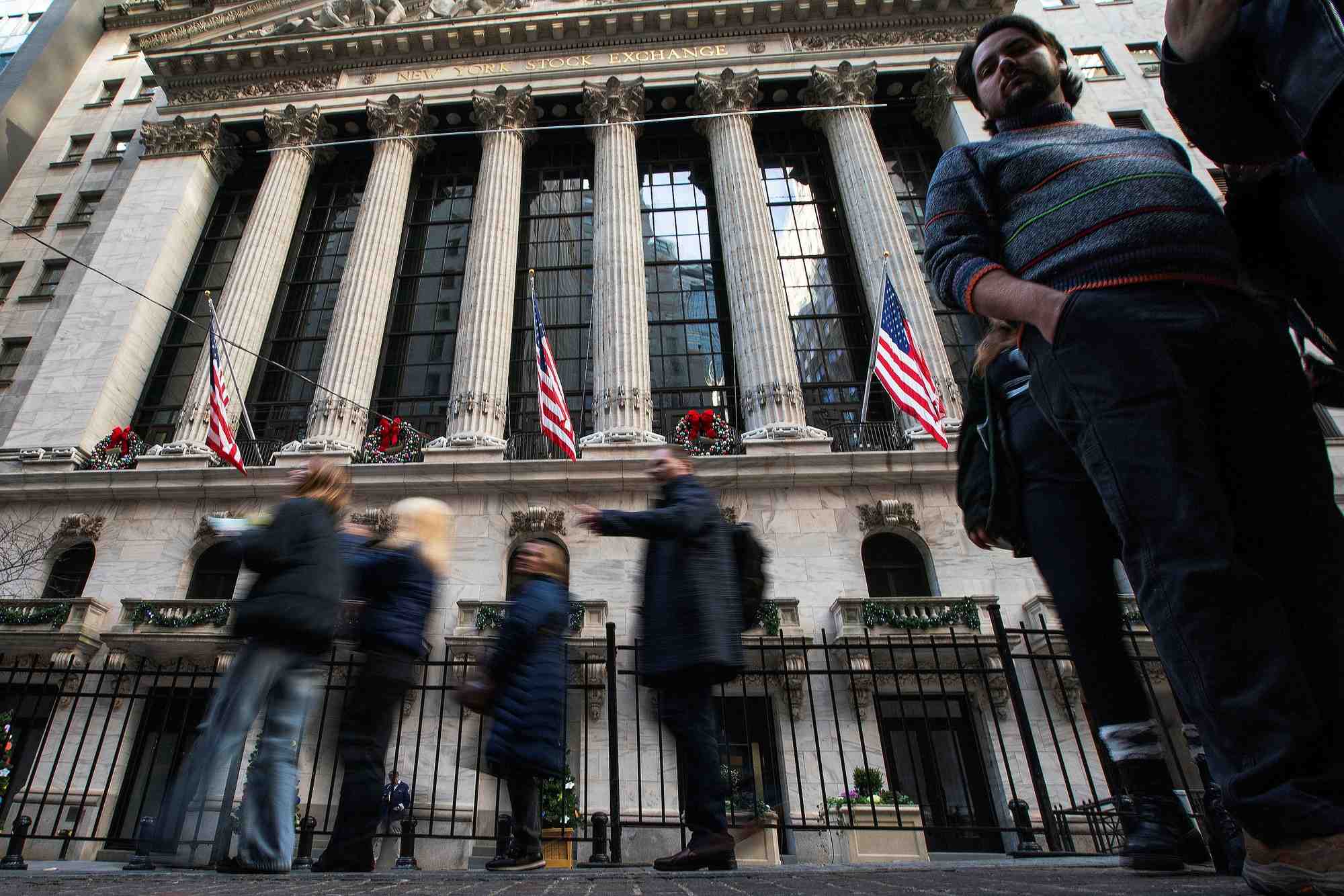 Des personnes marchent devant le new york stock exchange