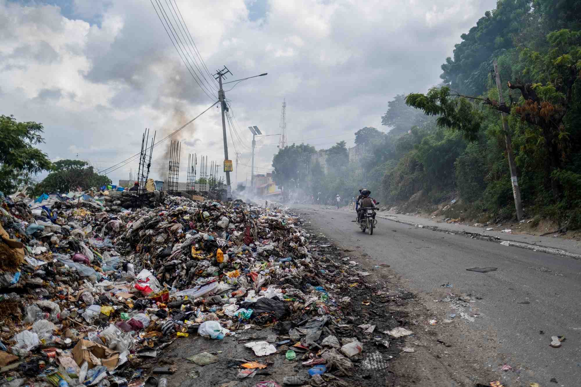Des dechets brulent sur le bord d'une route a port-au-prince, en haiti