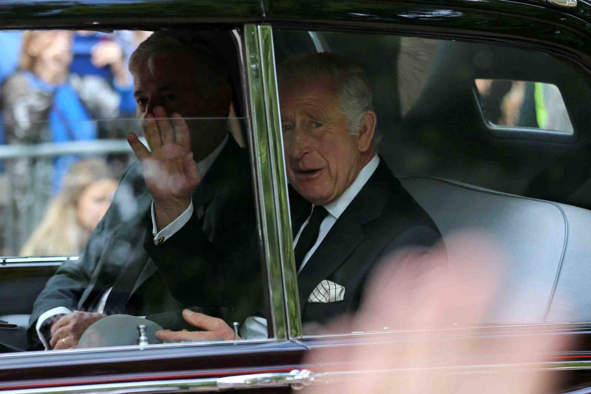 Le roi charles iii salue la foule alors que son vehicule traverse le centre de londres