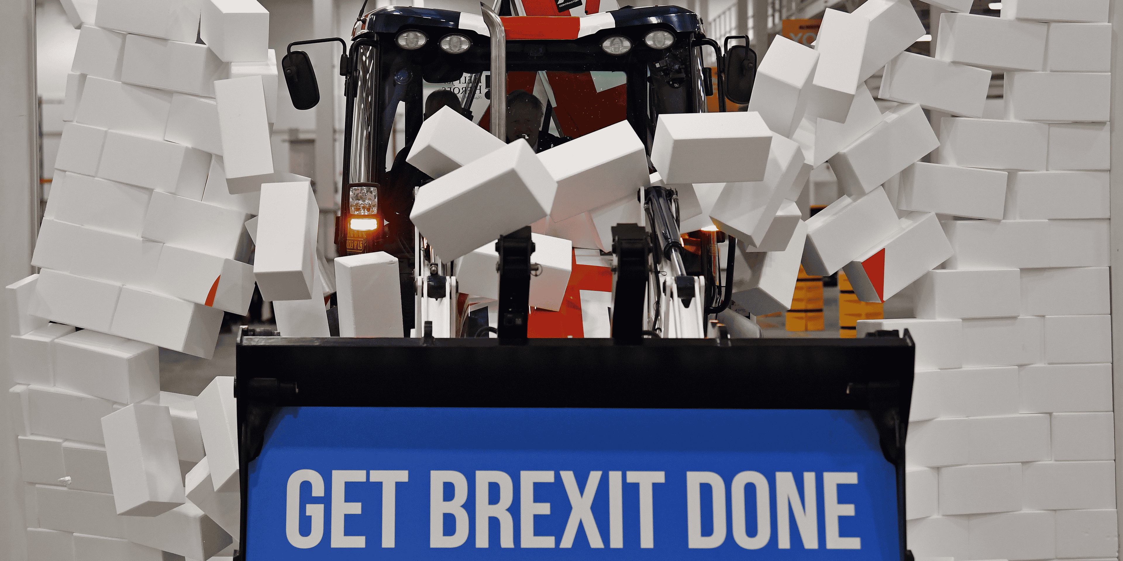 En pleine campagne pour les législatives, Boris Johnson fonce, au volant d'un bulldozer aux couleurs britanniques, vers un mur en briques de polystyrène sur lequel on peut lire le mot "impasse".