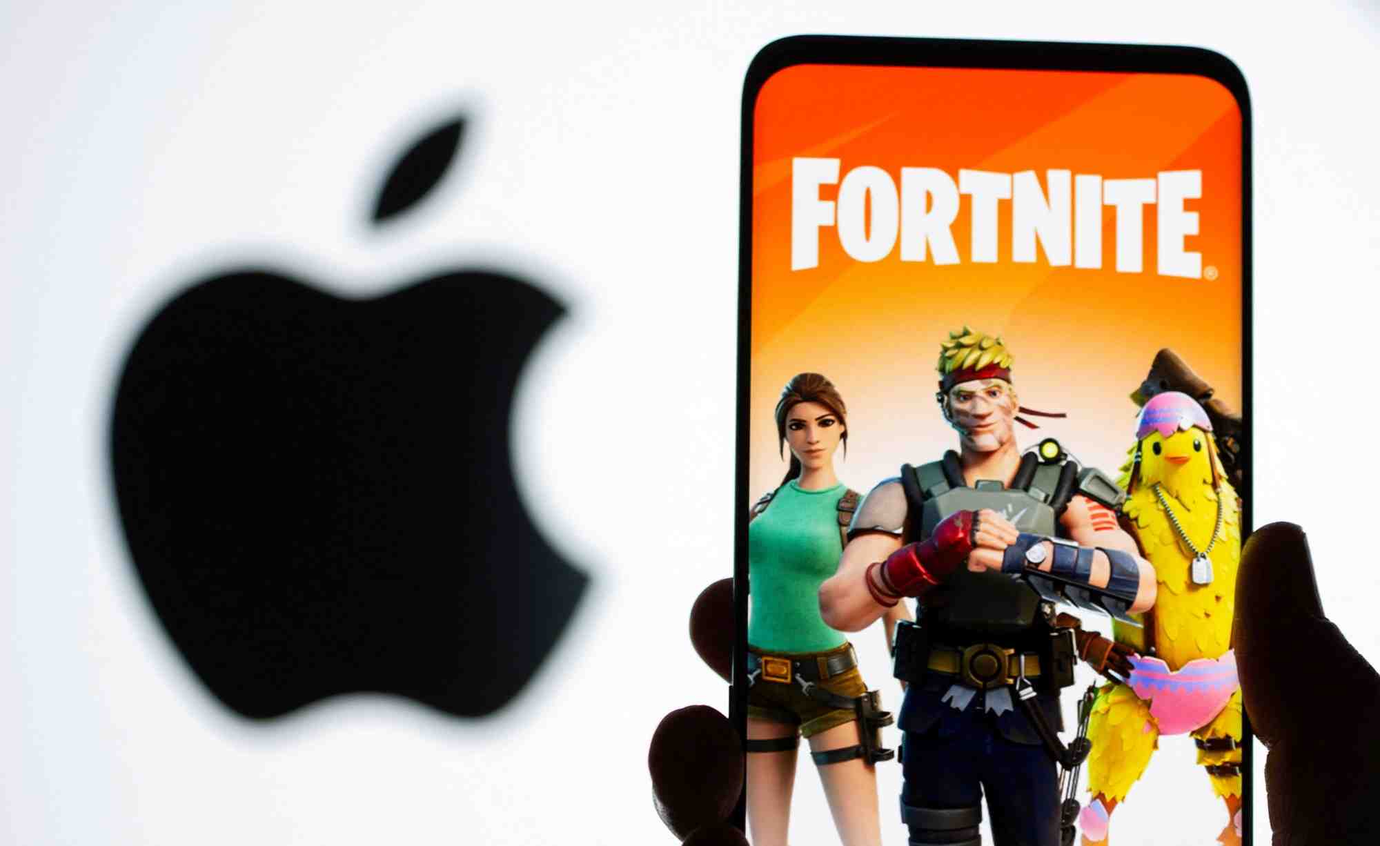 Image du jeu fortnite affichee sur un smartphone devant le logo d'apple