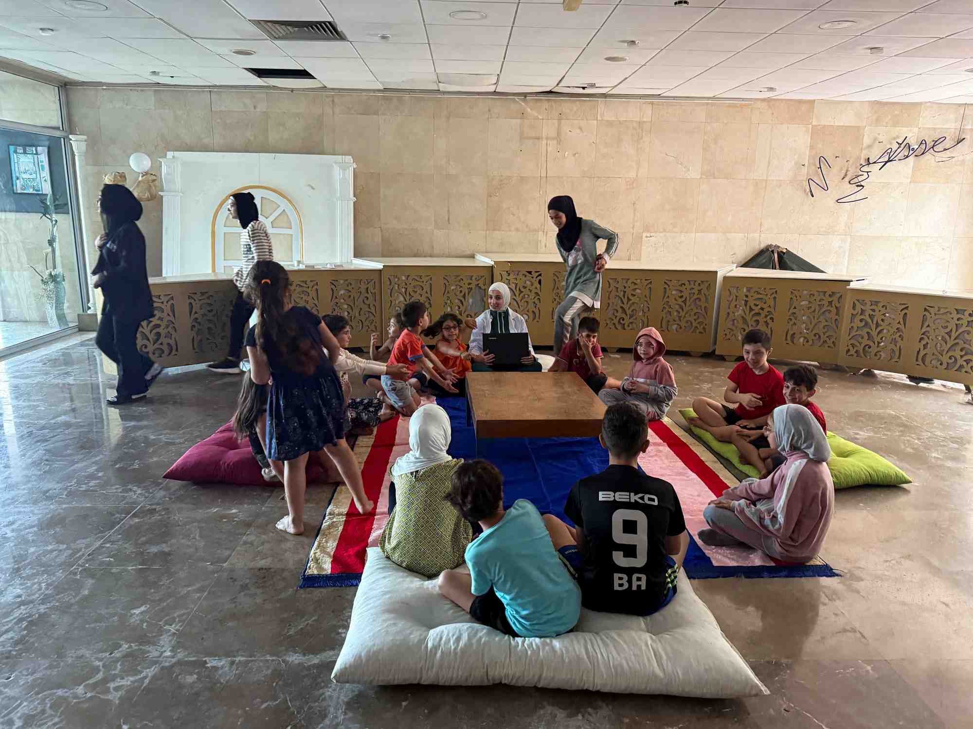Displaced people who fled from southern lebanese villages, sit together at an out-of-service hotel turned into a shelter hosting them, in tripoli