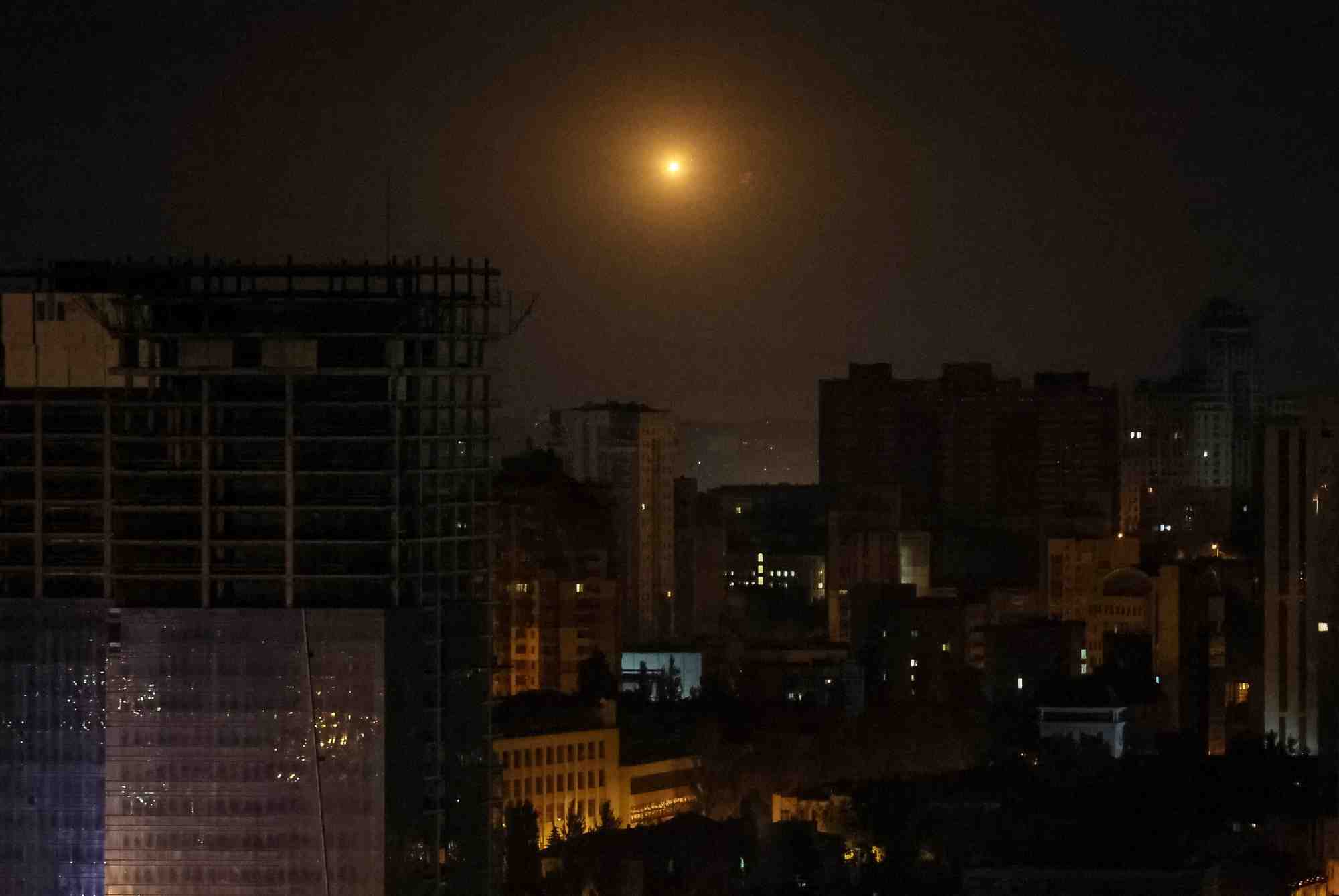 Photo d'une explosion d'un drone visible dans le ciel au-dessus de la ville lors d'une frappe de drones russes