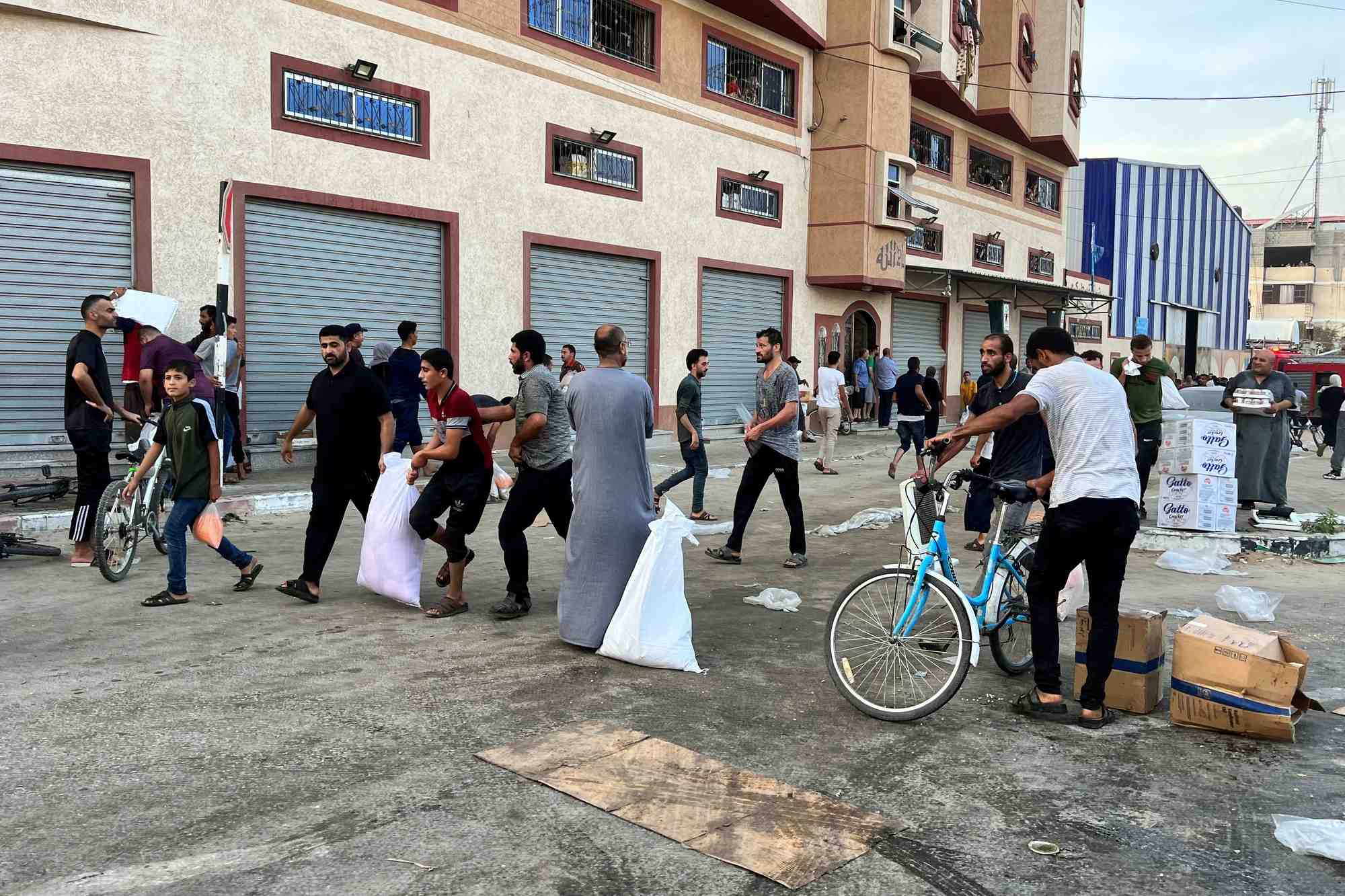 Des palestiniens transportent des vivres pres d'un entrepot gere par l'agence des nations unies pour les refugies palestiniens (unrwa) a khan younis