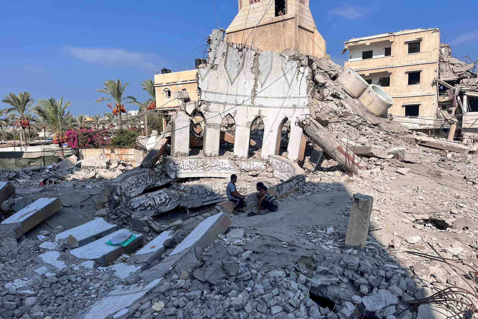 Des enfants palestiniens sont assis sur les decombres d'une mosquee detruite lors d'une frappe israelienne