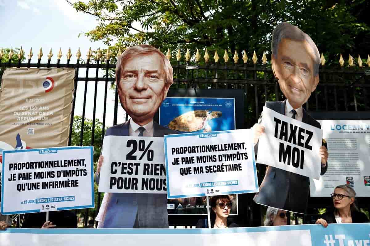 Des militants d’Attac, Oxfam France et 350.org brandissent des pancartes sur lesquelles on peut lire « Taxez-moi » et des cartons représentant le milliardaire français Vincent Bolloré et Bernard Arnault, président-directeur général de LVMH Moët Hennessy Louis Vuitton, lors d’une manifestation près du Sénat français alors que les sénateurs commencent à débattre du projet de loi de gauche sur l’impôt sur la fortune pour les ultrariches, à Paris le 12 juin 2025.
