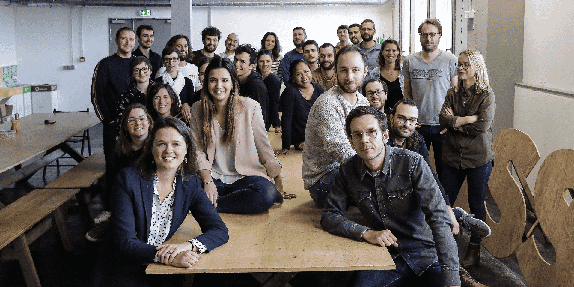 Léa Thomassin, au 1er rang, et une partie de l'équipe d'HelloAsso dans les locaux de l'entreprise à la Cité numérique, à Bègles.