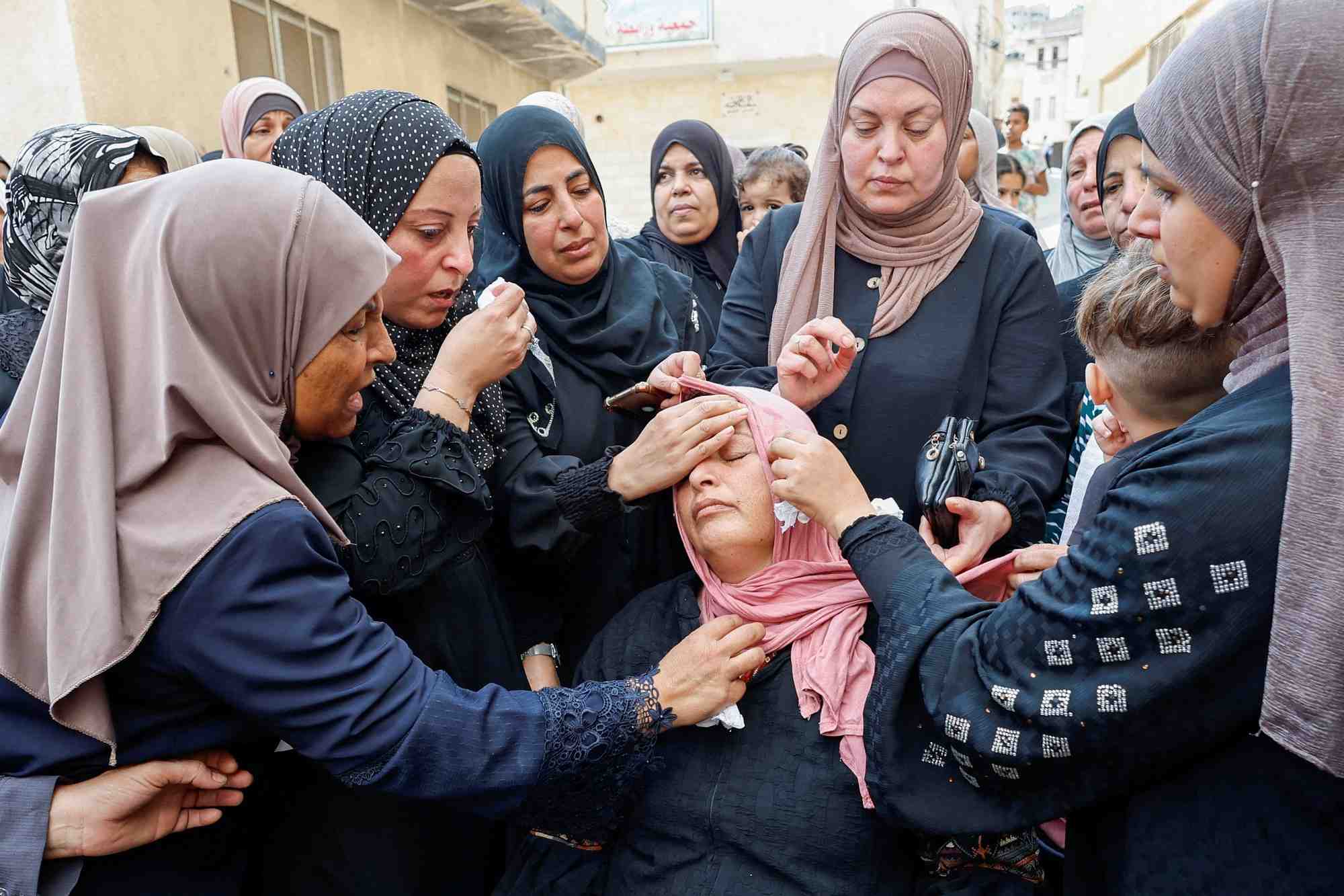 Des femmes consolent la mere du palestinien mateen dbaya, tue a la suite d'un raid des forces israeliennes dans le camp de refugies de djenine