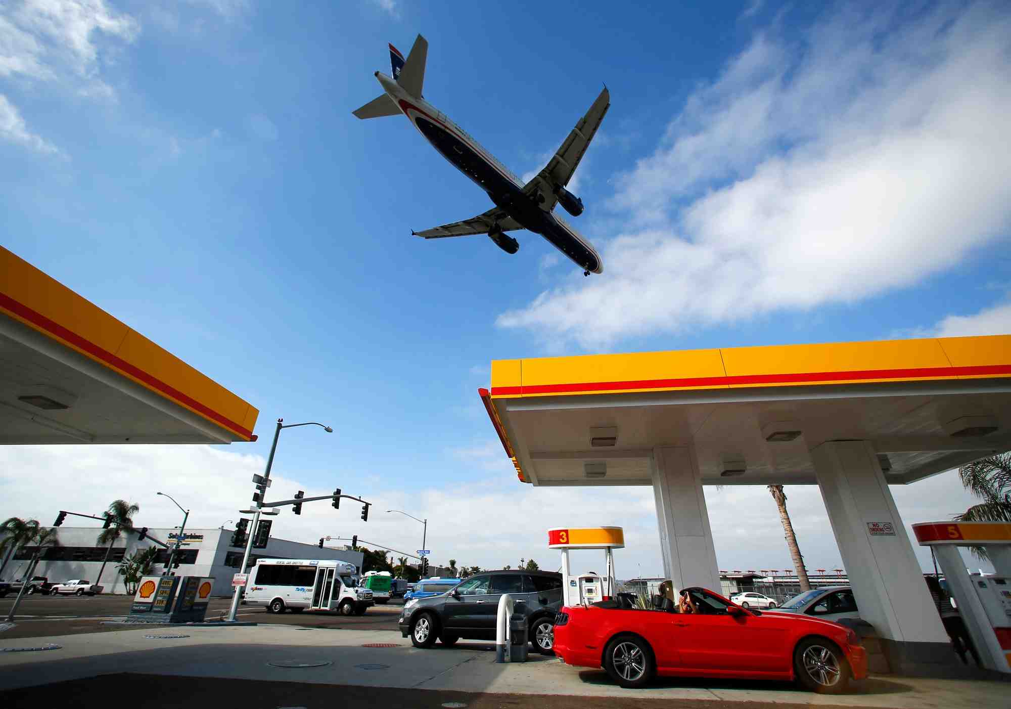 Un avion survole une station-service shell alors qu'il s'approche pour atterrir a l'aeroport de san diego en californie