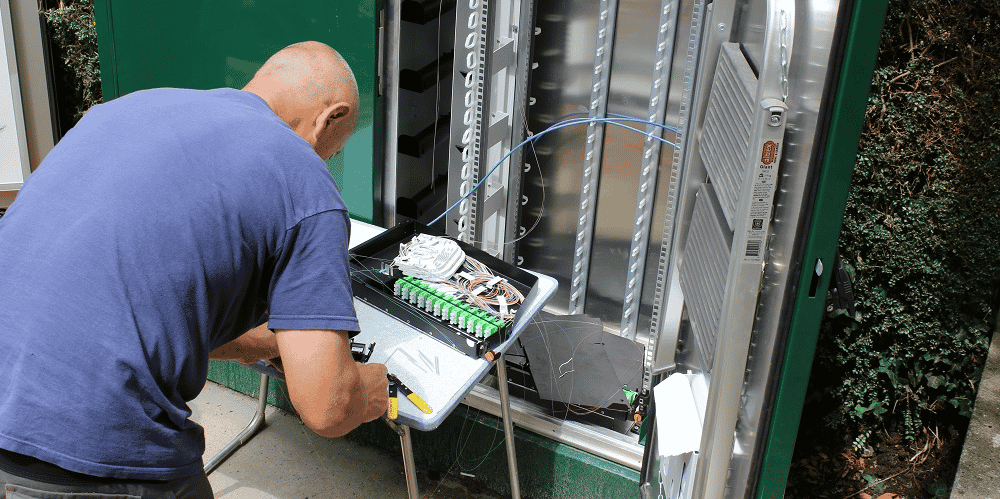 Un technicien raccorde, ici, un particulier à la fibre.