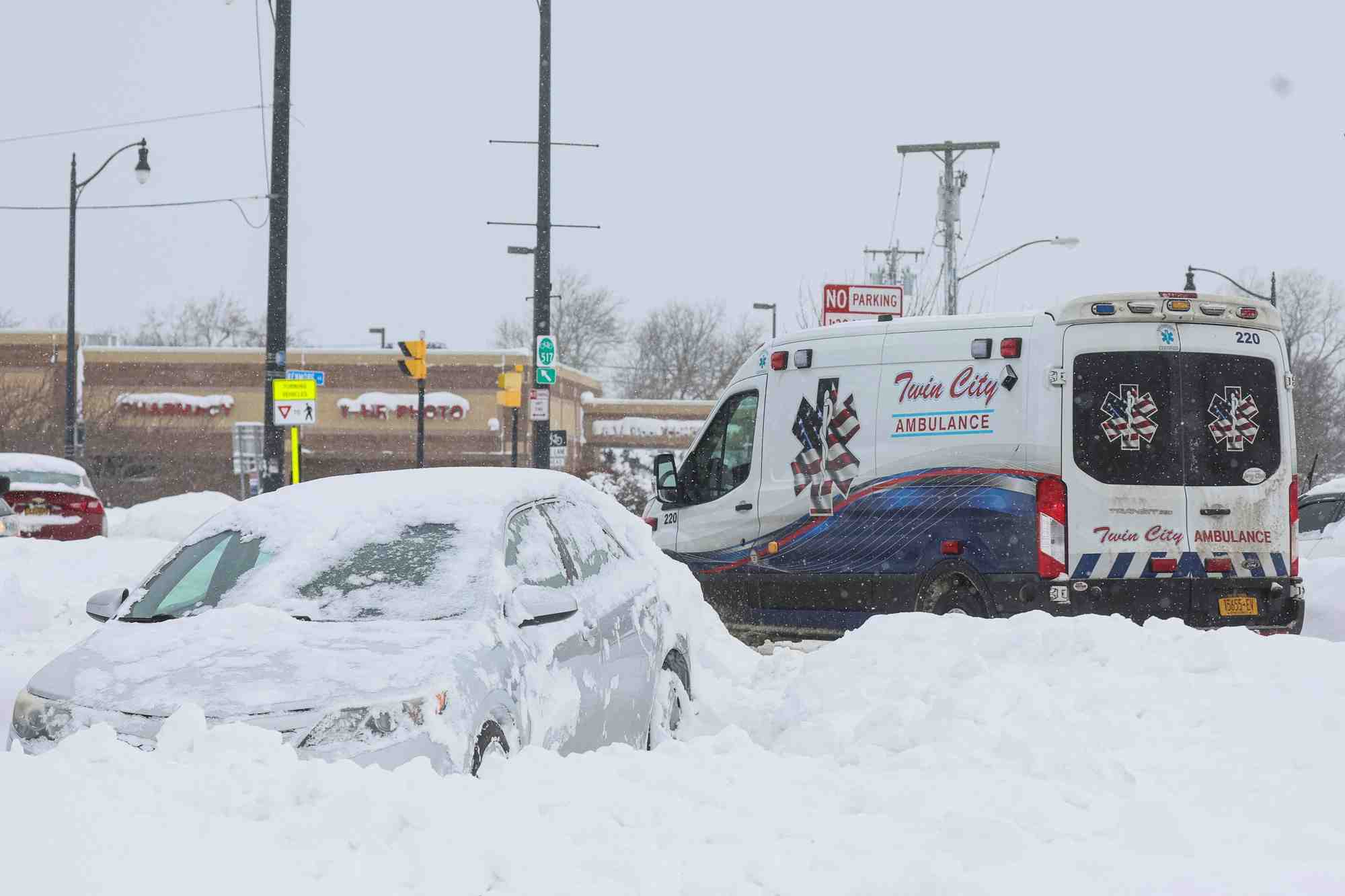 Une ambulance passe devant une voiture abandonnee pendant une tempete hivernale qui a frappe la region de buffalo
