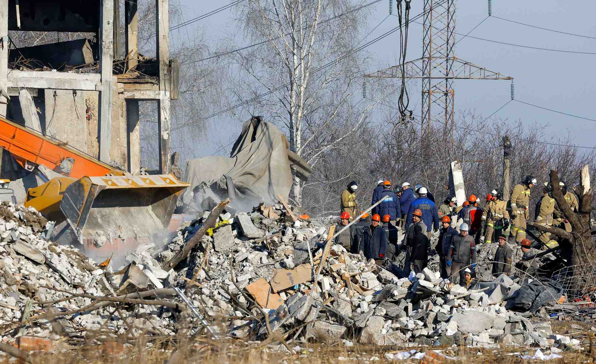 Des ouvriers et des membres du ministere des situations d'urgence enlevent les debris d'un batiment detruit cense etre un college professionnel utilise comme logement temporaire pour les soldats russes, a makiivka