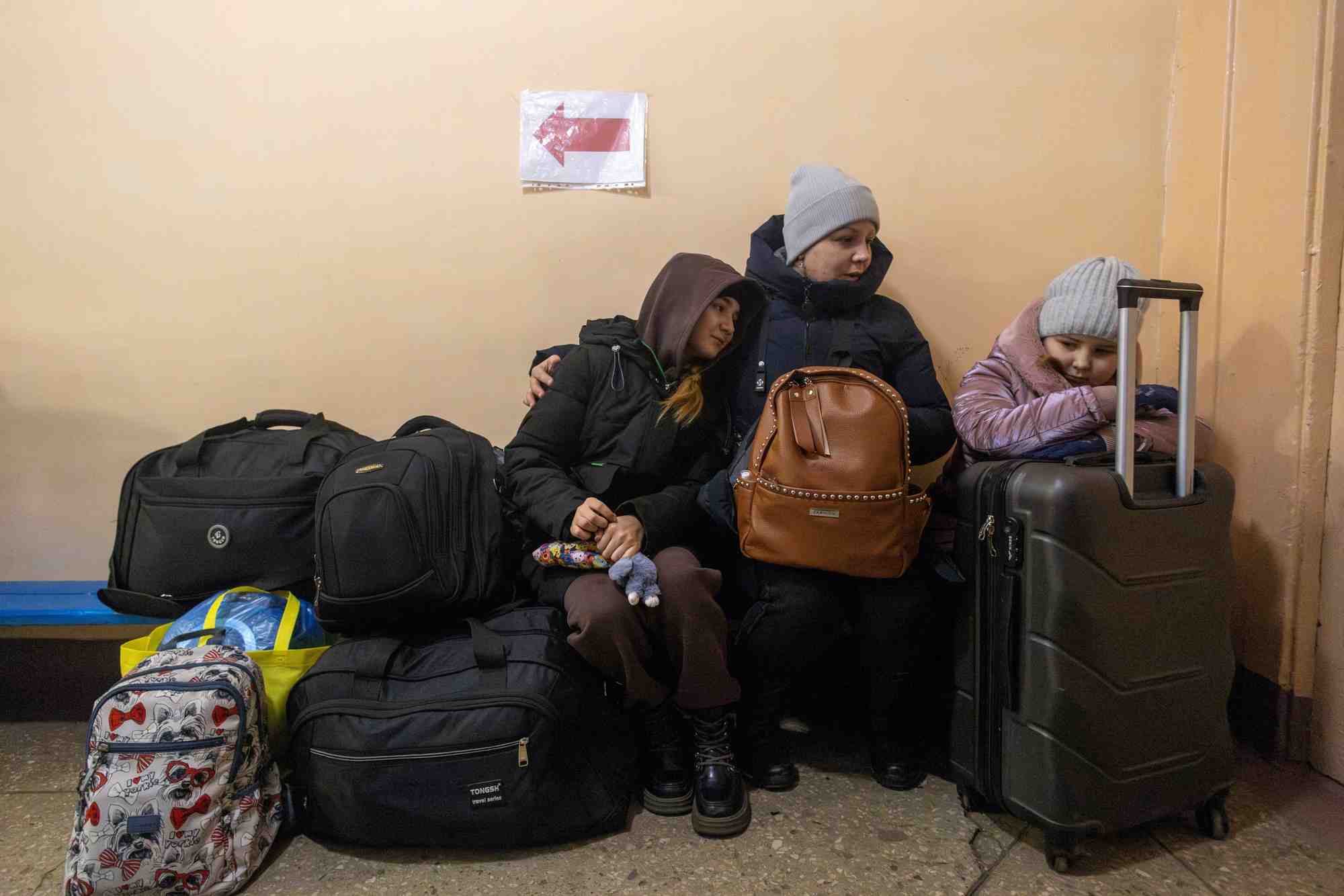 Une femme et ses enfants attendent un train d’evacuation a pokrovsk, en ukraine