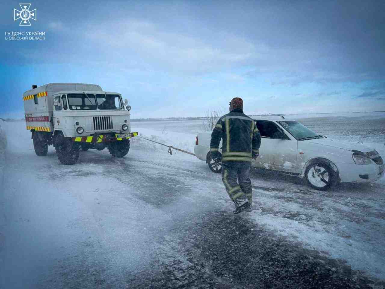 Photo des secouristes qui liberent une voiture coincee dans la neige suite a une forte tempete de neige dans la region d'odessa