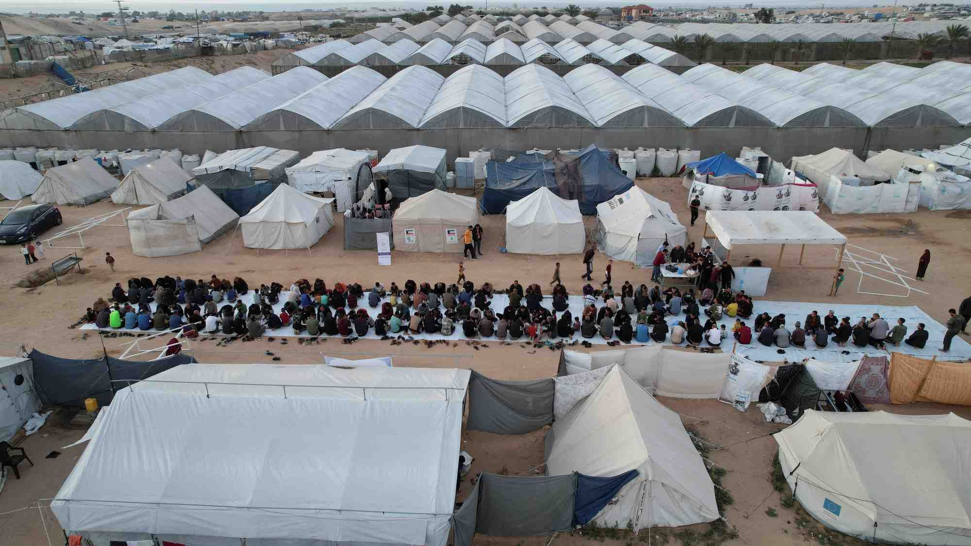 Une vue de drone montre des palestiniens, deplaces par l'offensive militaire israelienne, se rassemblant pour l'iftar (rupture du jeune) pendant le mois sacre du ramadan, a rafah, dans le sud de la bande de gaza
