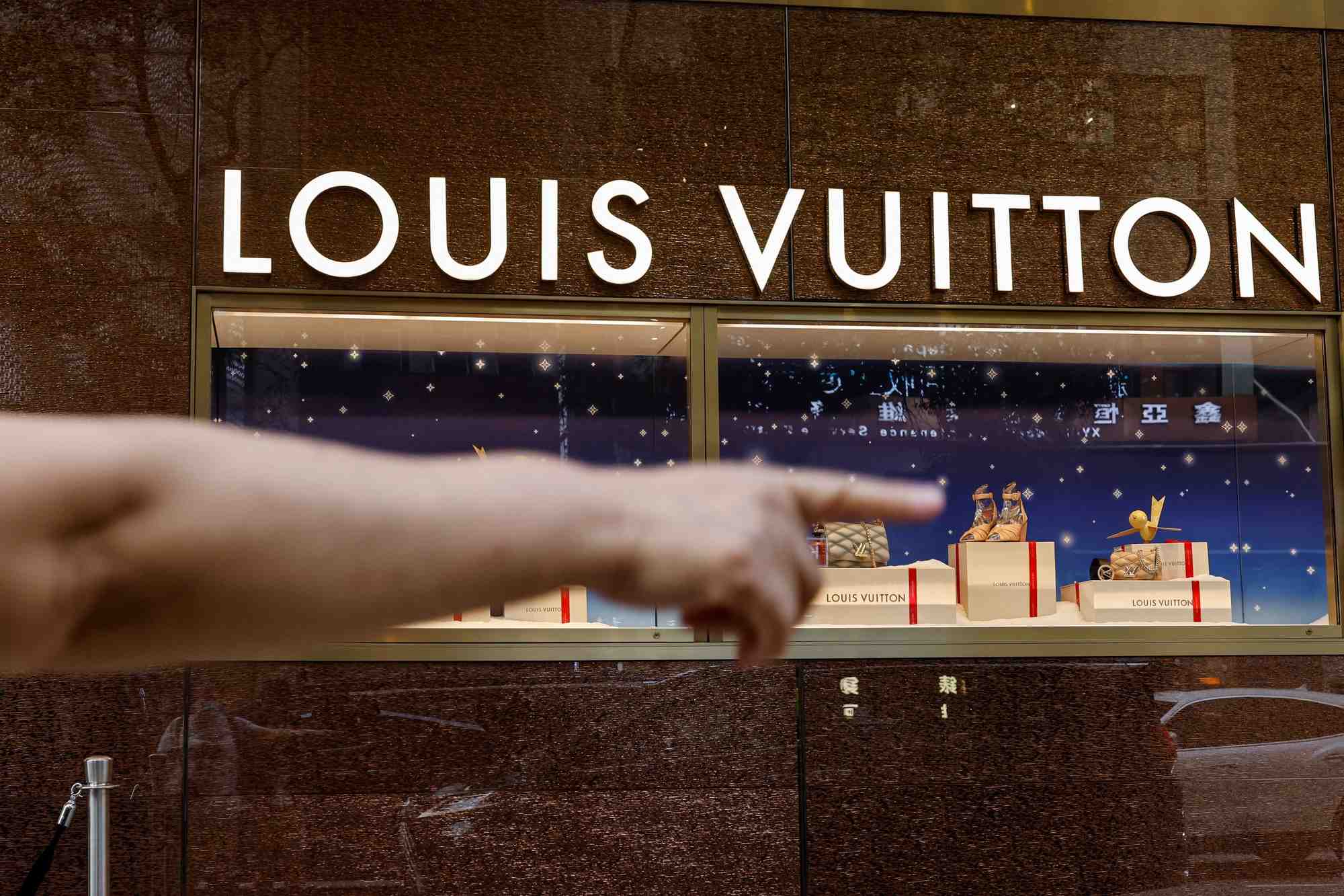Un touriste devant un magasin louis vuitton a tsim sha tsui, un quartier commercant anime, a hong kong.