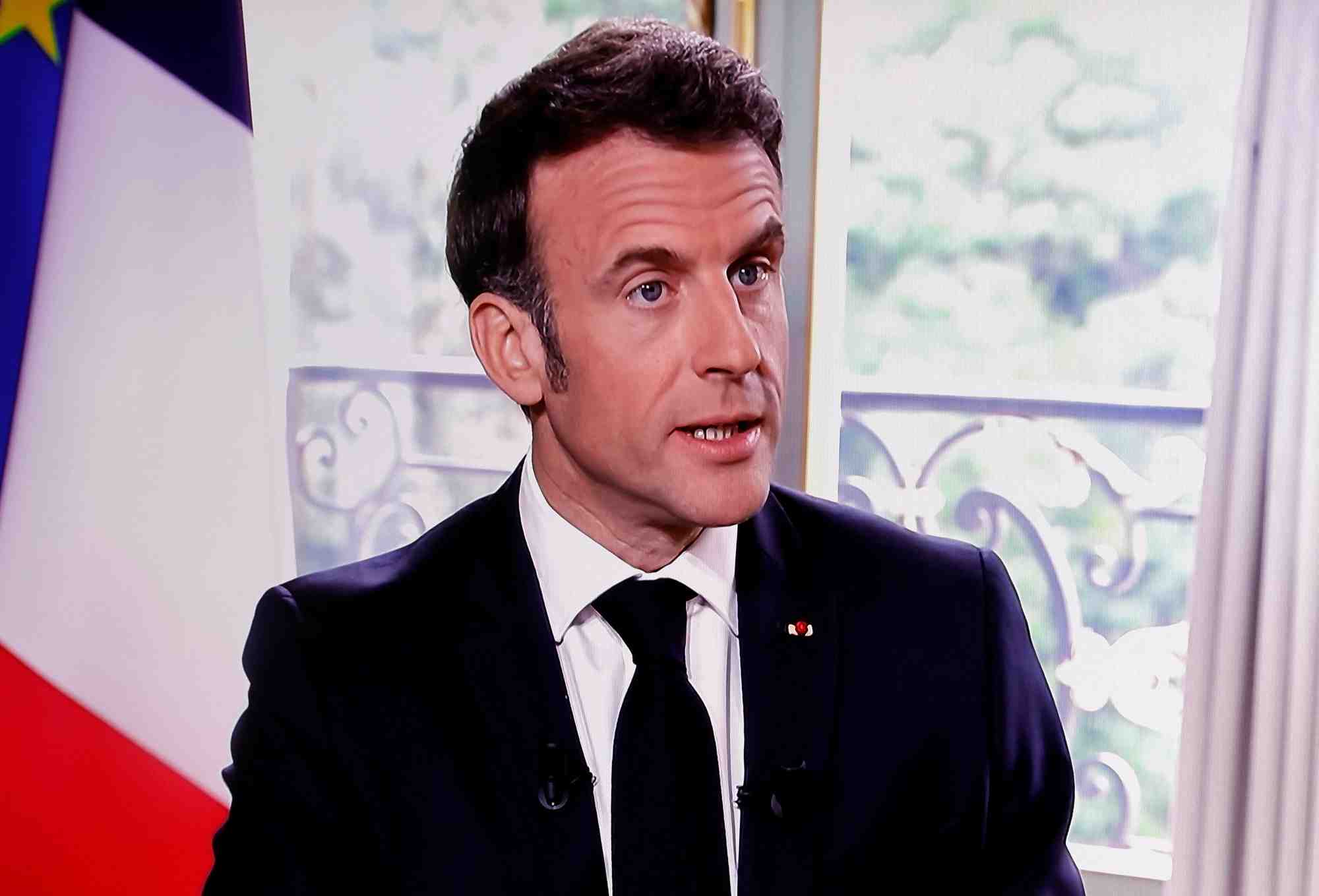 Le president francais macron est vu sur un ecran alors qu'il assiste a une interview a paris