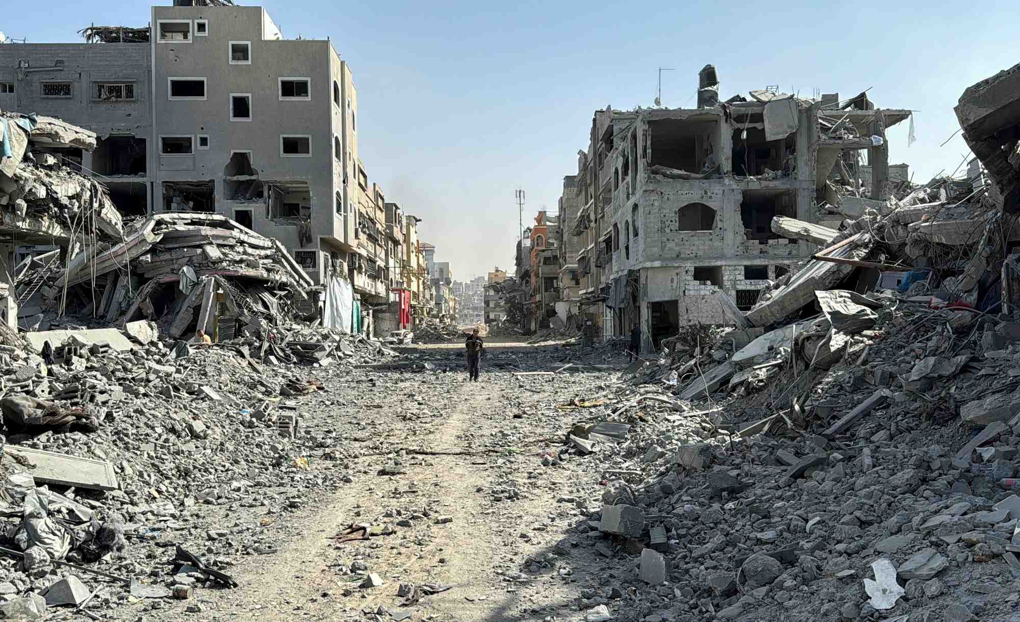 Un palestinien marche devant les decombres autour de l'hopital kamal adwan