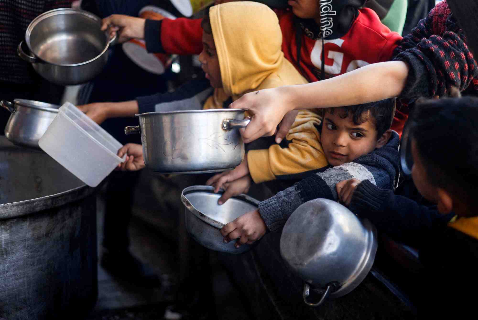 Des enfants palestiniens attendent de recevoir de la nourriture a rafah