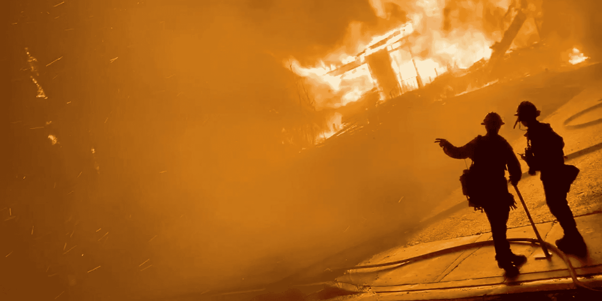 Deux pompiers devant une maison en feu lors d’incendies de forêt, le 31 octobre 2019 à San Bernardino, en Californie (capture d’écran obtenue à partir d’une vidéo de média social).