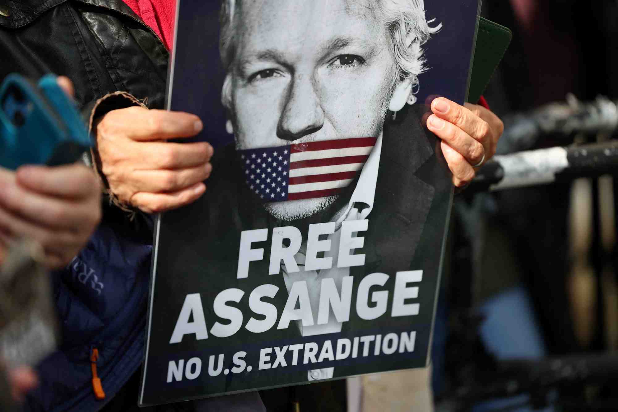 Photo d'un partisan du fondateur de wikileaks, julian assange, qui tient une pancarte