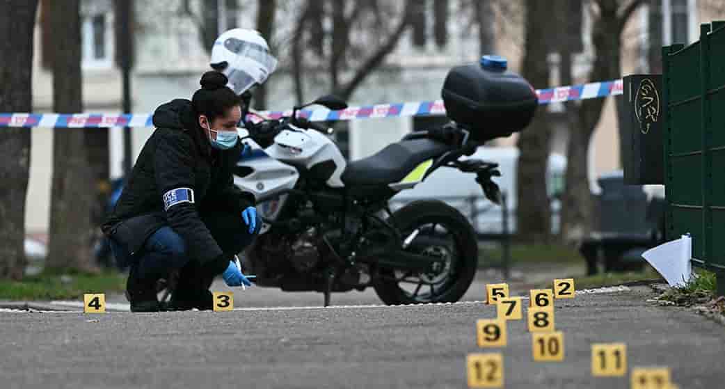 Une enquêtrice de la police judiciaire recueille des preuves sur le site de l’attaque à l'arme blanche où un homme est soupçonné d'avoir tué une personne et blessé deux policiers municipaux à Mulhouse ce 22 février.