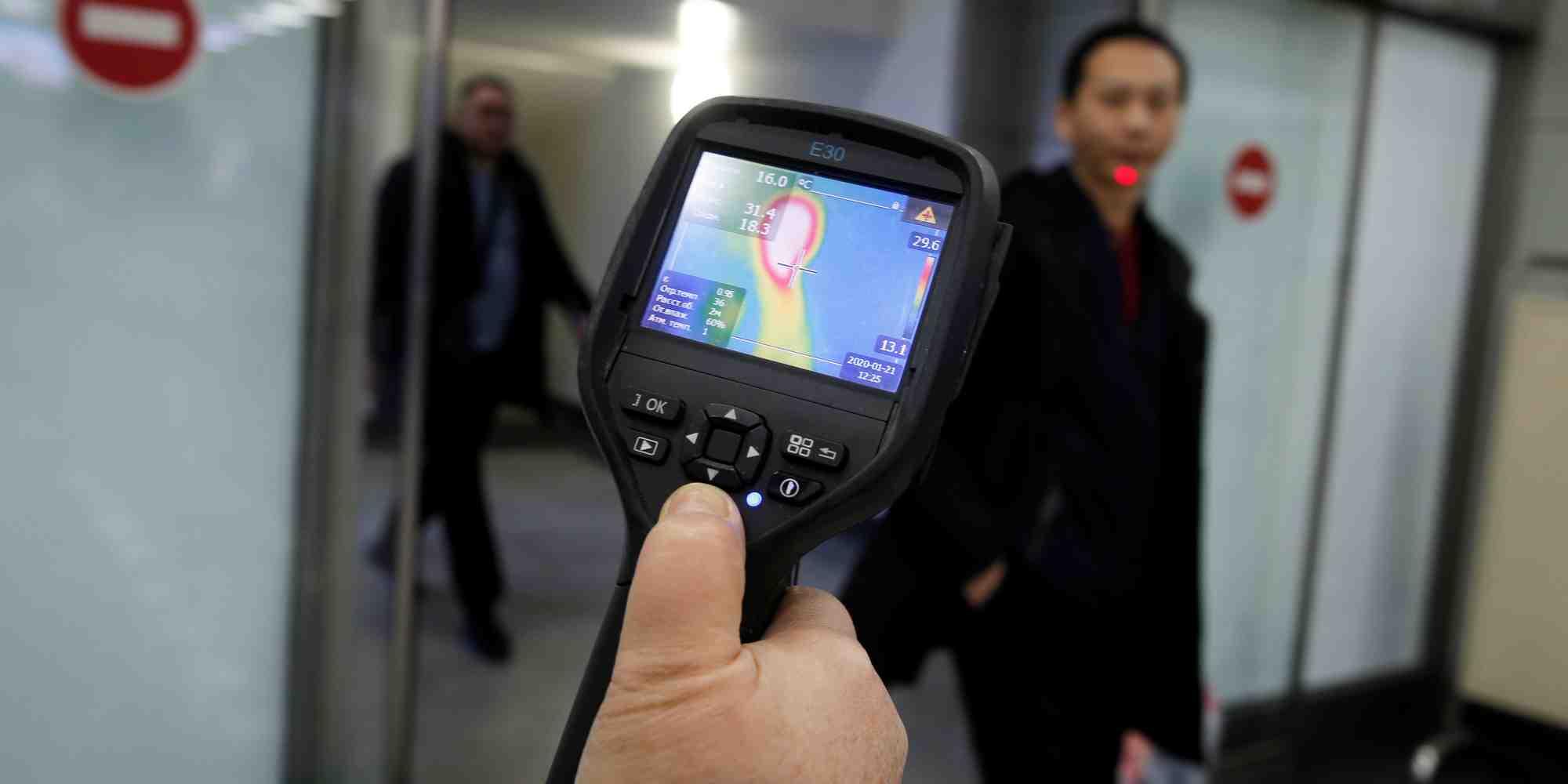 Le 21 janvier 2020, à l'aéroport international, un employé des services sanitaires et épidémiologiques kazakh utilise un scanner thermique pour détecter les voyageurs en provenance de Chine à leur arrivée au Kazakhstan qui pourraient présenter des symptômes liés au nouveau coronavirus chinois .