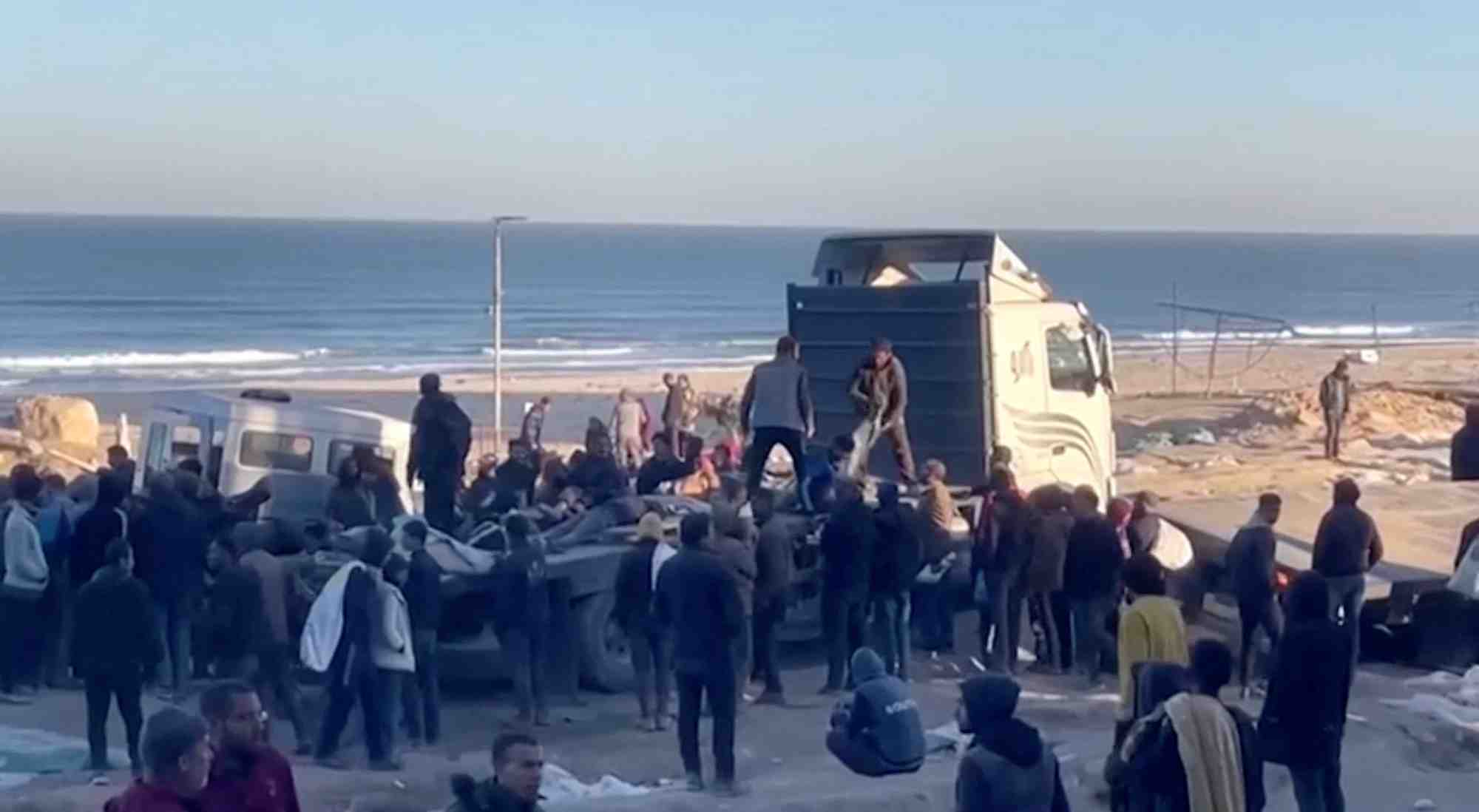 Des palestiniens transportent des blesses a la suite de tirs israeliens sur des personnes attendant de l'aide, dans la ville de gaza