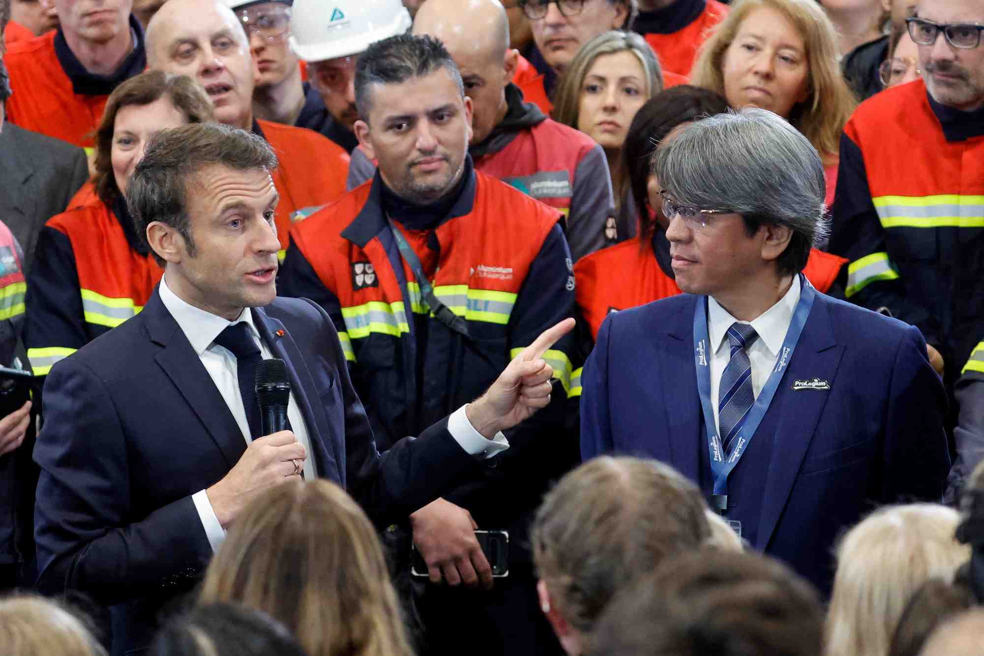 Emmanuel macron s'adresse a des employes a cote de vincent yang