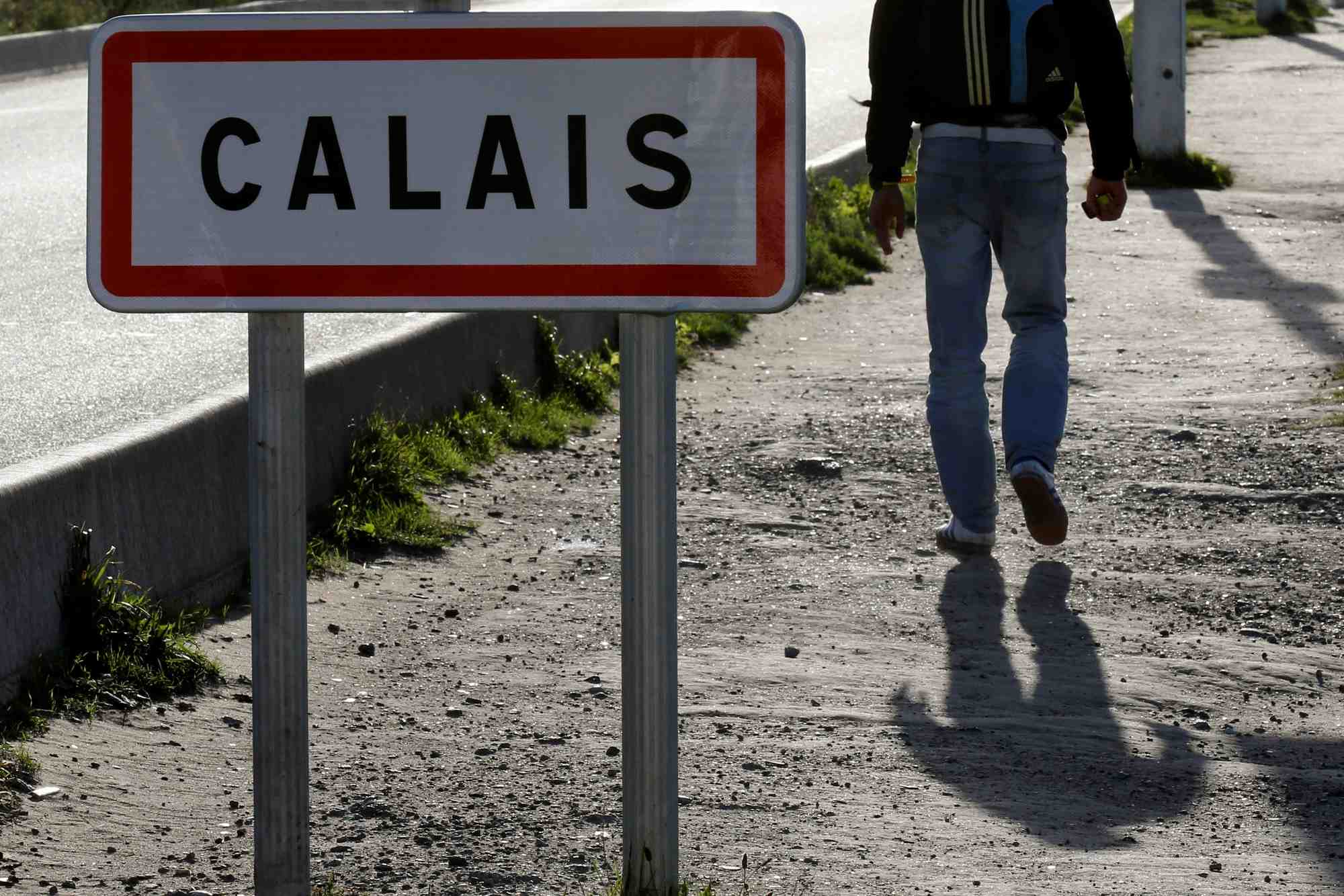 Un migrant passe devant un panneau a calais