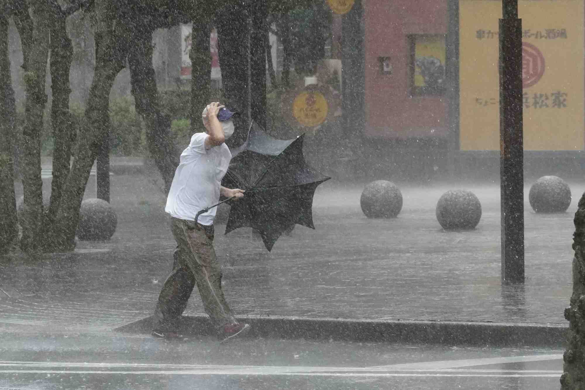 Un homme marche dans la rue alors que de fortes pluies tombent a hamamatsu, au japon