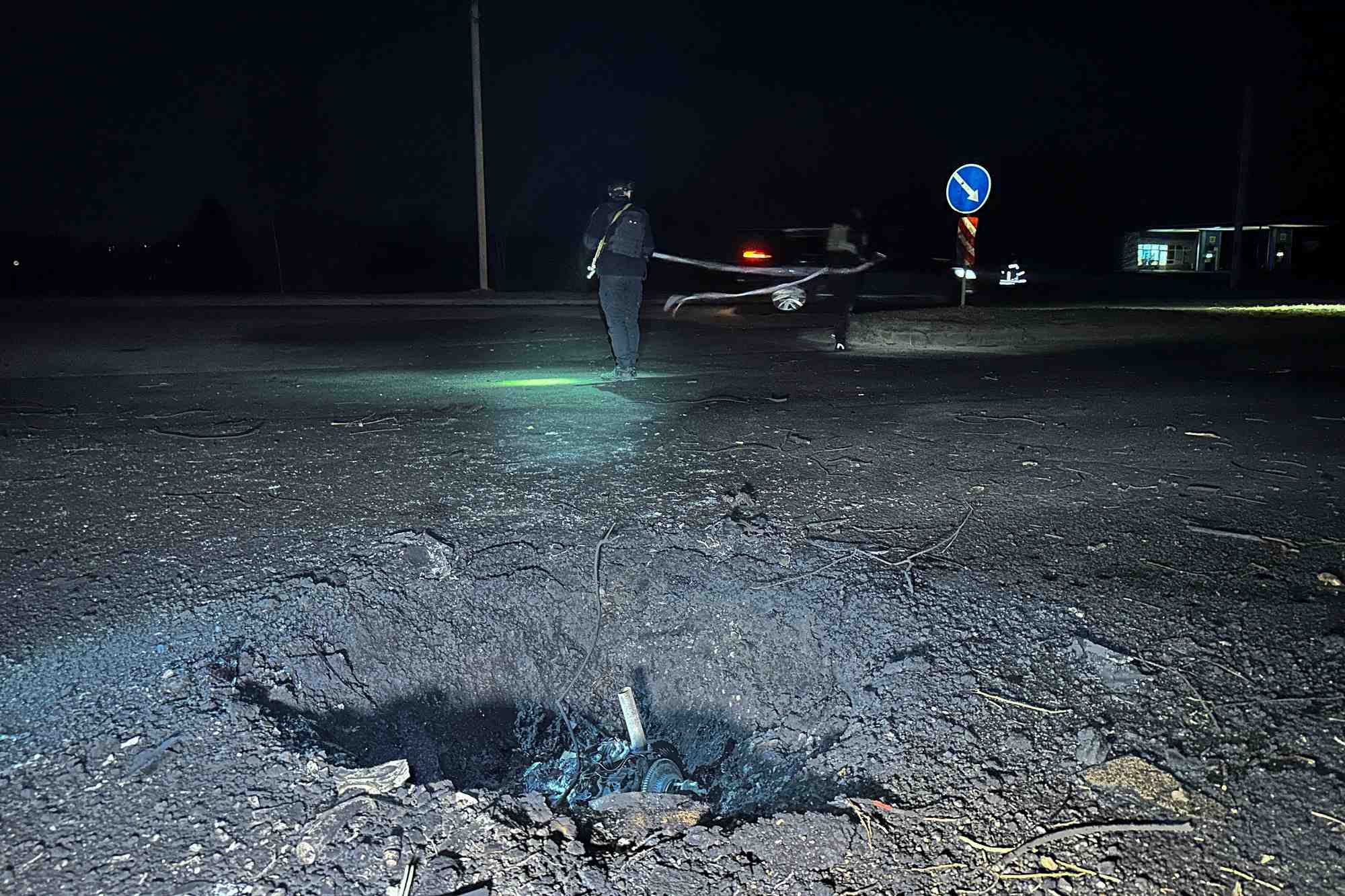 Des policiers travaillent a cote d'un cratere apparu apres une frappe de drone russe, dans le cadre de l'attaque de la russie contre l'ukraine, a kharkiv