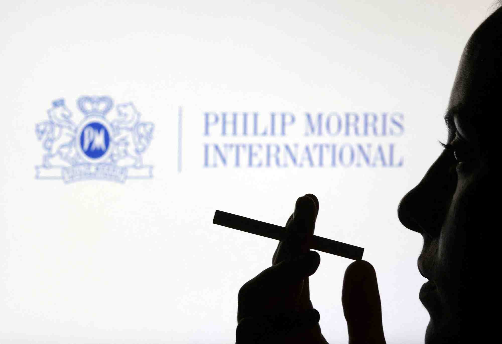 Une femme avec une cigarette devant le logo de philip morris international