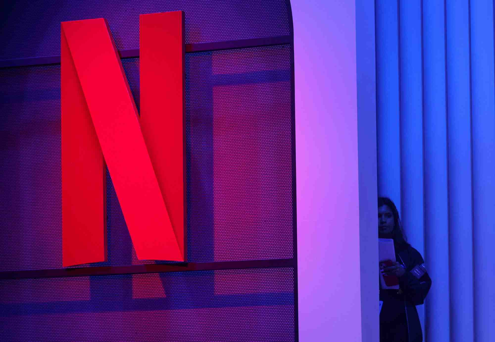 Une femme se tient a cote d'un logo de netflix lors d'un evenement a mumbai