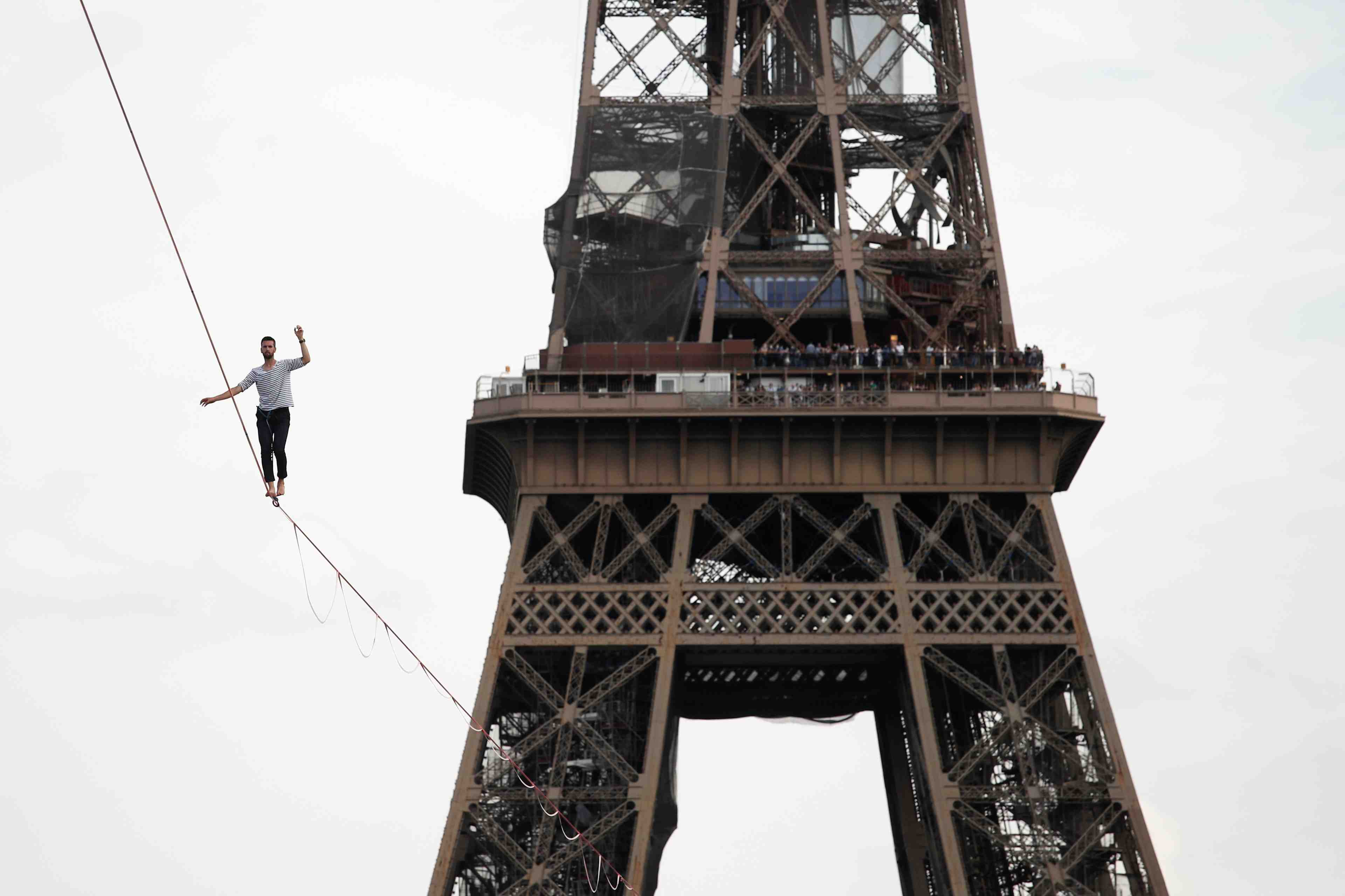 A paris, nathan paulin relie la tour eiffel au theatre de chaillot suspendu a une sangle