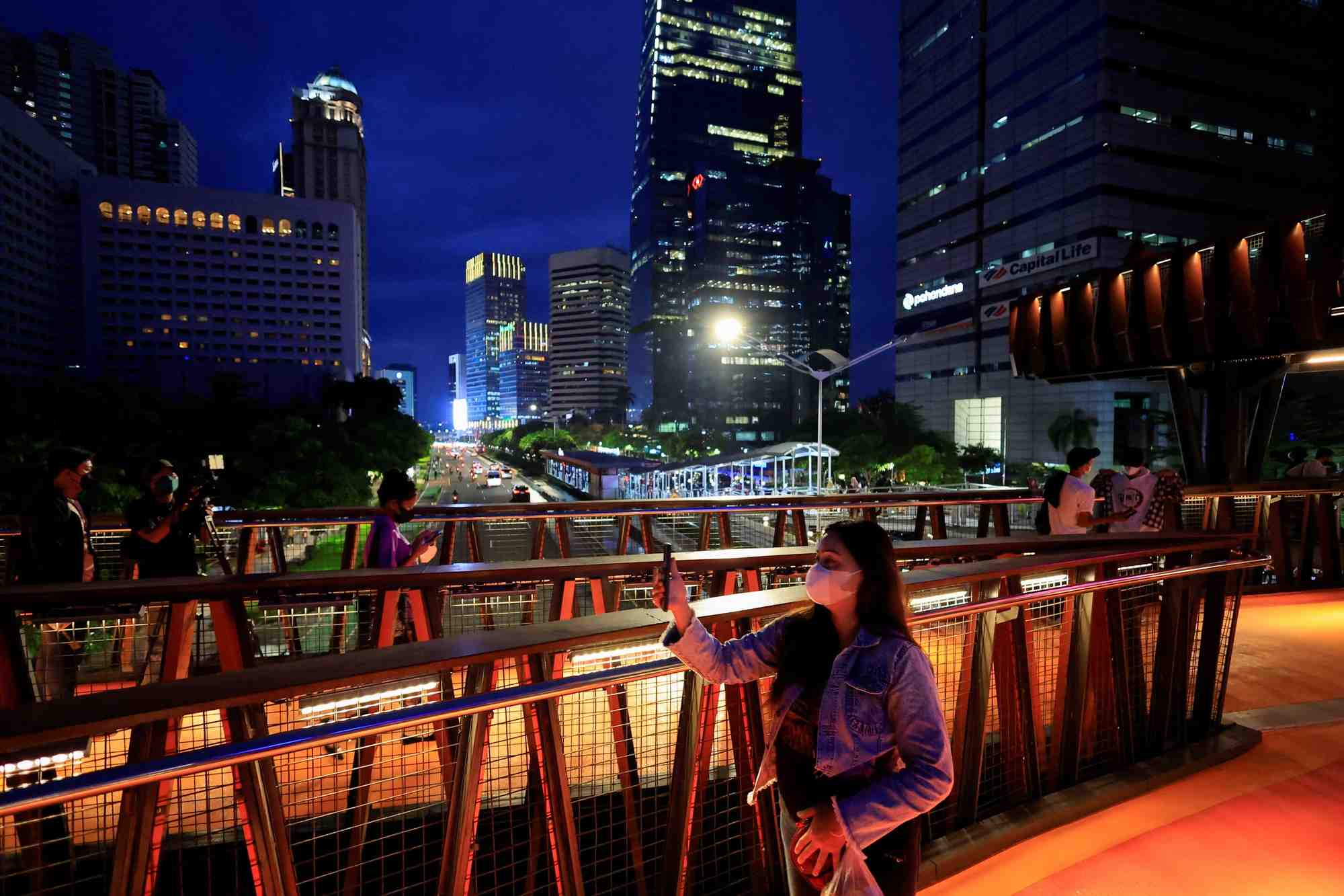 Des personnes portant des masques sur un pont pietonnier a jakarta