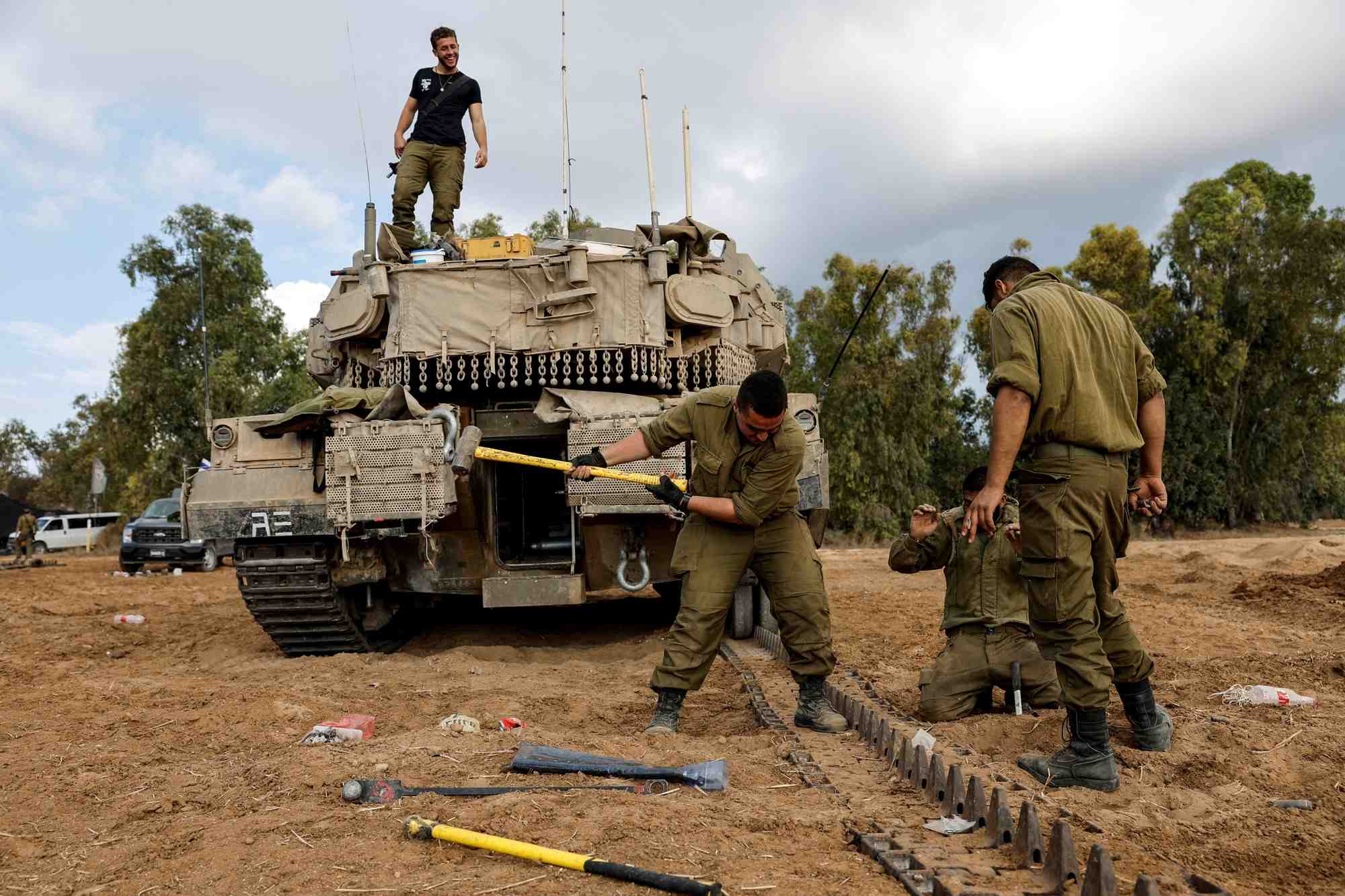 Des soldats israeliens reparent un char pres de la frontiere entre israel et la bande de gaza