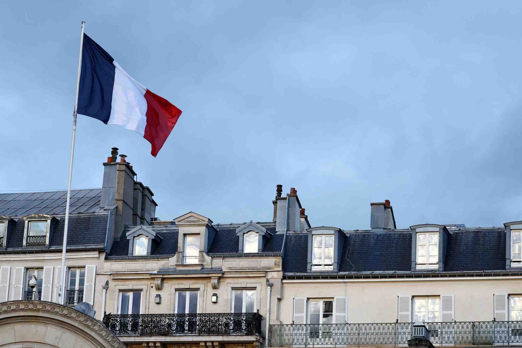 Photo d'un drapeau francais qui flotte au-dessus de l'entree du palais de l'elysee