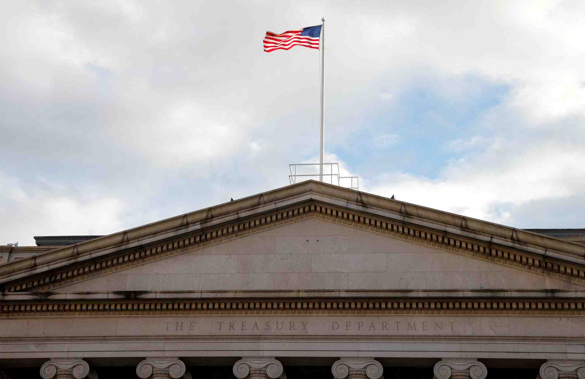 Photo d'archives d'un drapeau americain qui flotte au-dessus du batiment du treasury building