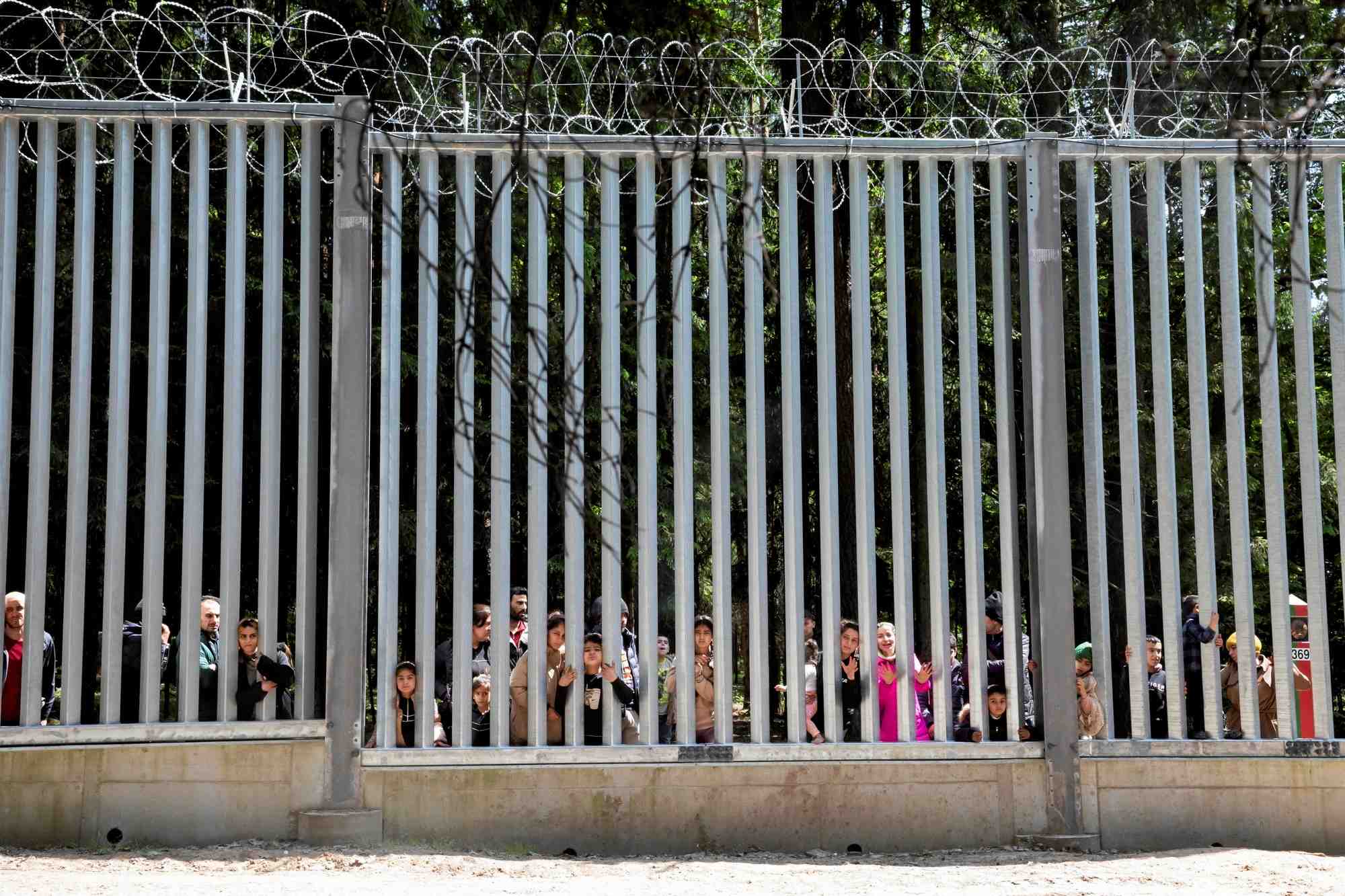 Des migrants se tiennent pres du mur a la frontiere entre la pologne et la bielorussie, pres de bialowieza
