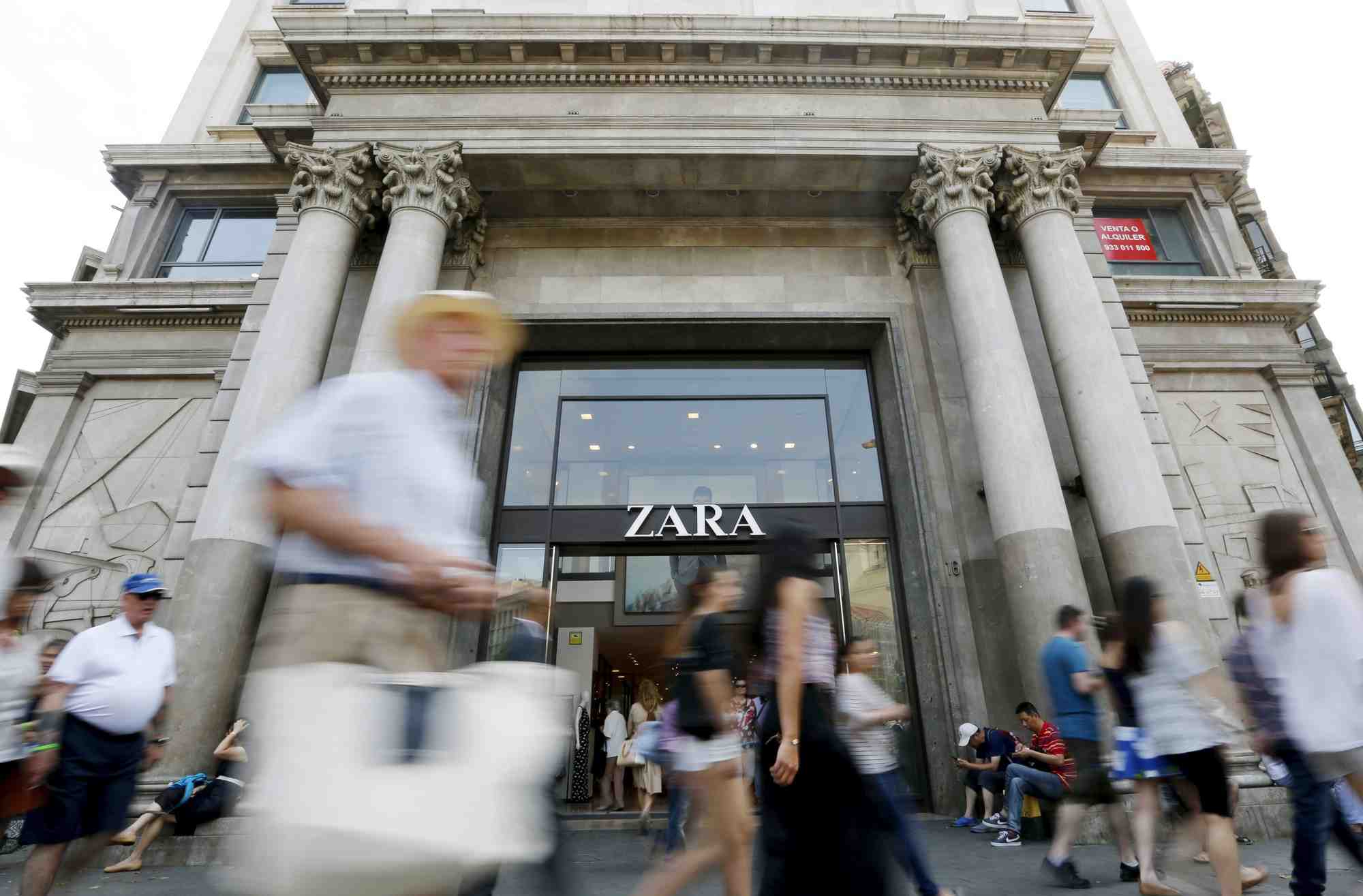 Des gens passent devant un magasin zara, dans la rue passeig de gracia a barcelone