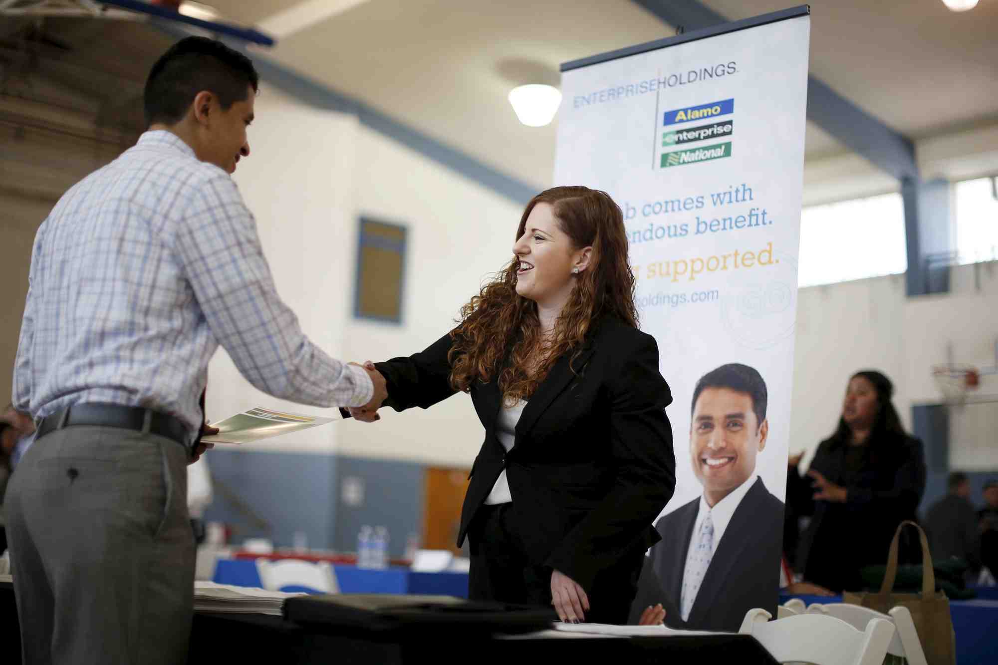 Photo d'archives: jessica kolber (a droite) serre la main d'un demandeur d'emploi lors d'un salon de l'emploi a los angeles