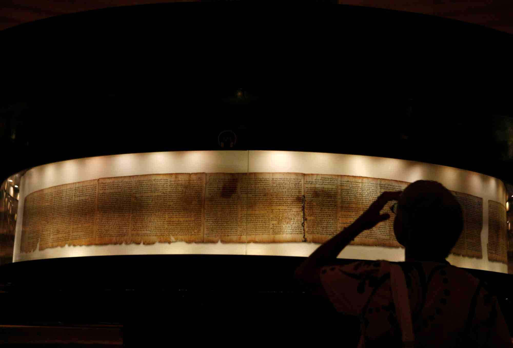 A visitor looks at a facsimile of the isaiah scroll displayed inside the shrine of the book at the israel museum in jerusalem