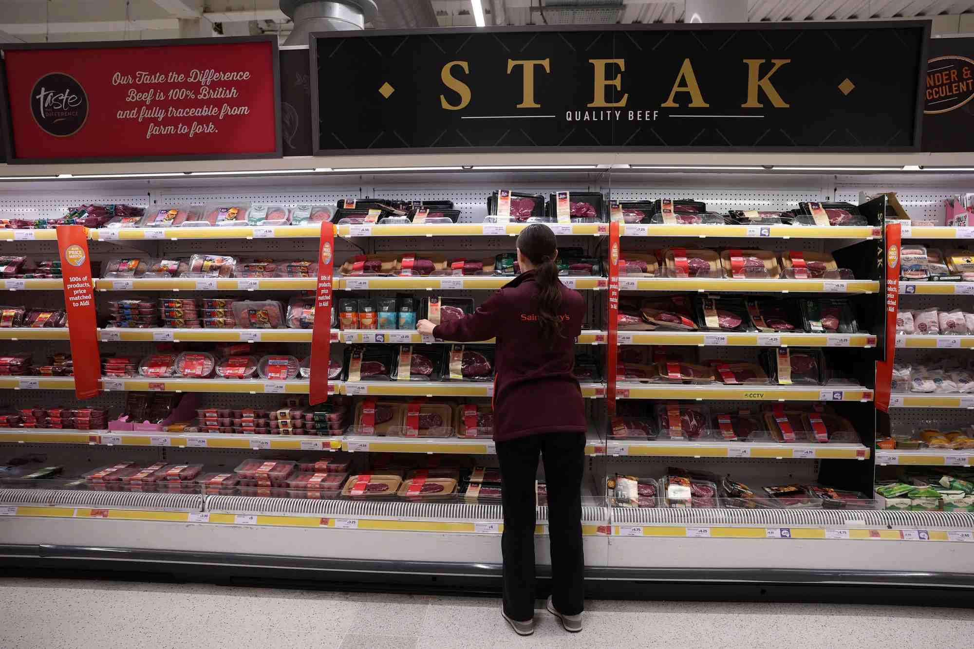 Un employe range des produits a l'interieur d'un supermarche sainsbury's a londres