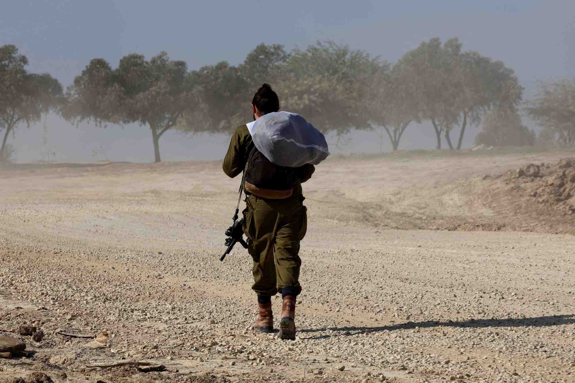 Un soldat israelien marche pres de la frontiere entre israel et gaza