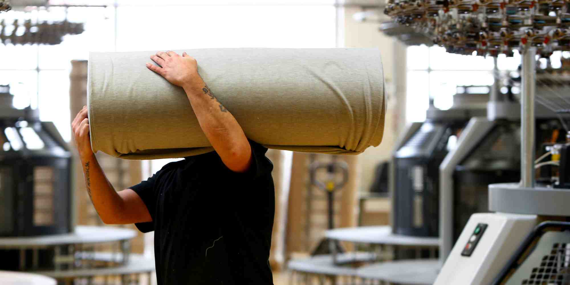 Un employe deplace des draperies dans l'usine de l'entreprise textile "trigema" a burladingen