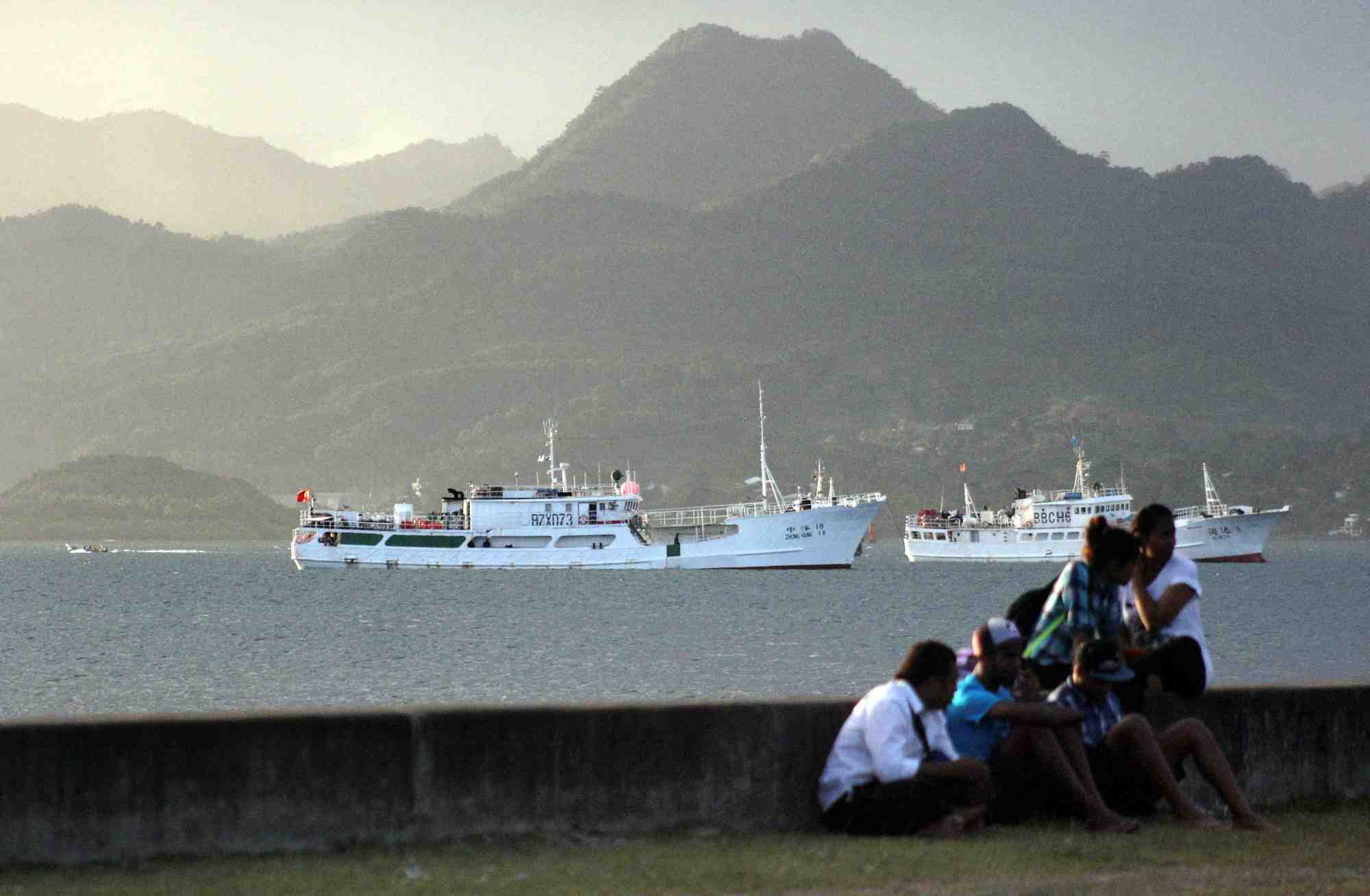 Photo d'archives : des habitants sont assis sur un mur du port de suva, la capitale des fidji