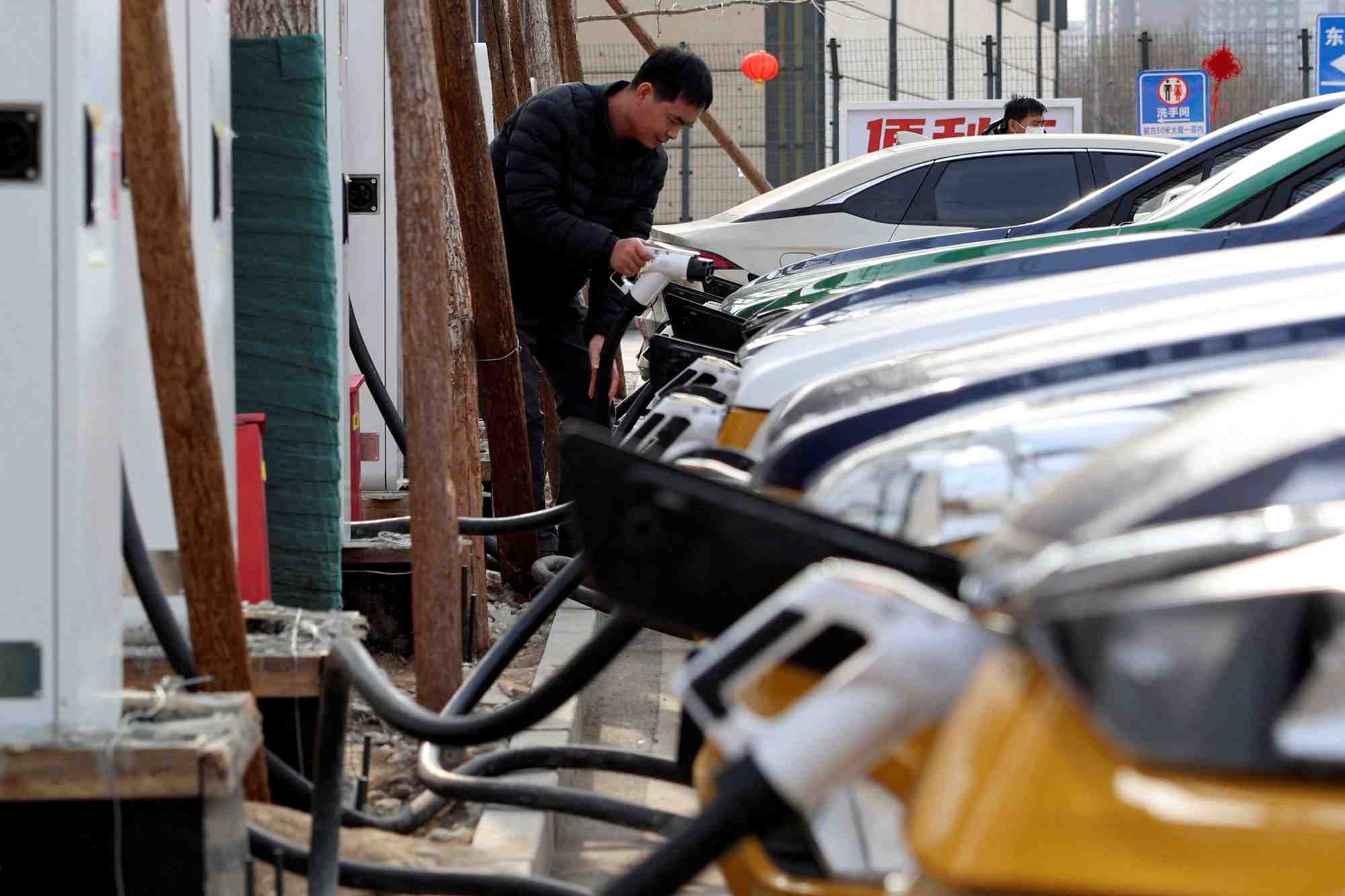 Photo d'archives: un homme a une station de recharge de vehicules electriques a pekin