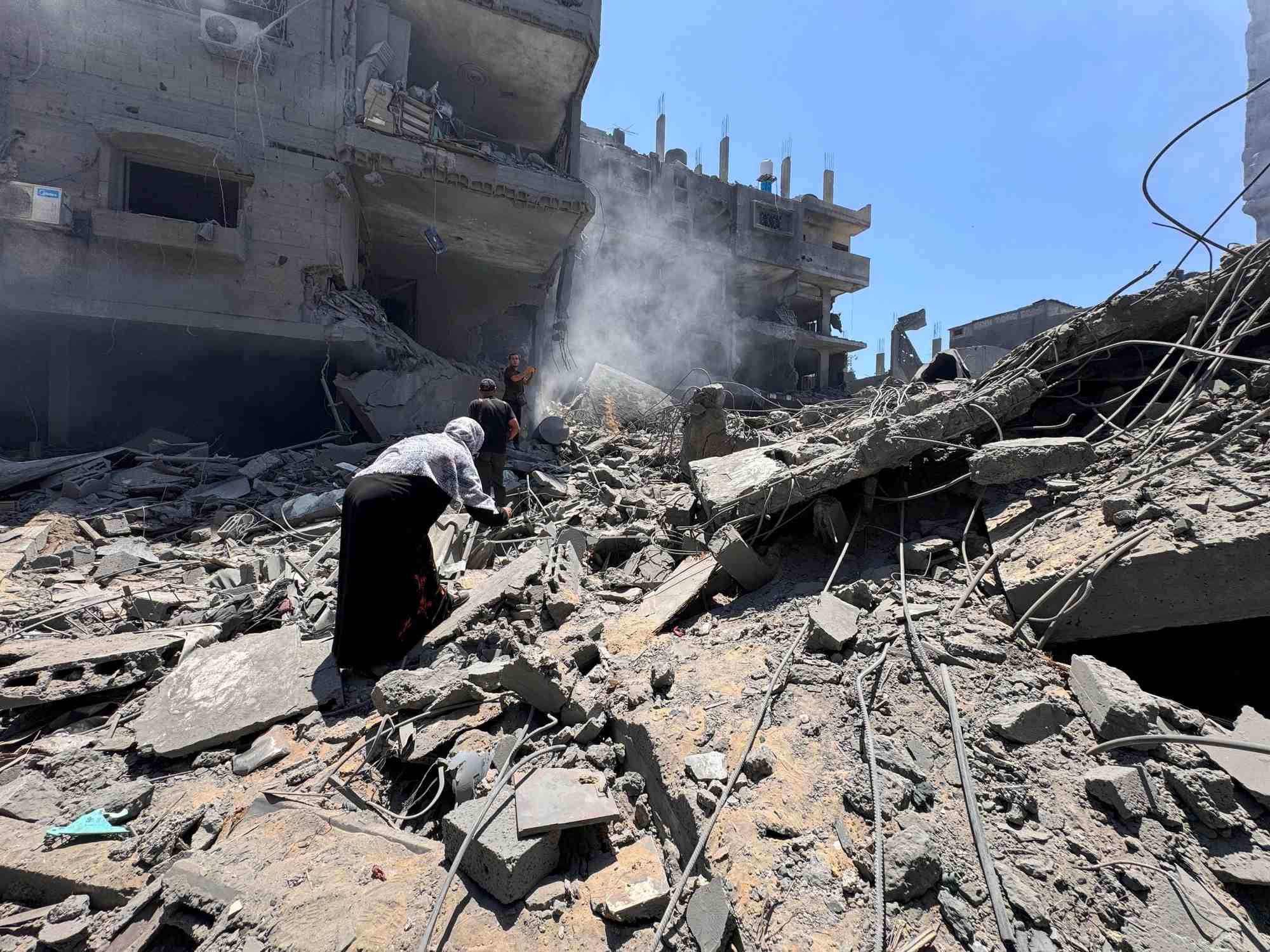 Palestinians search for casualties at the site of israeli strikes on houses