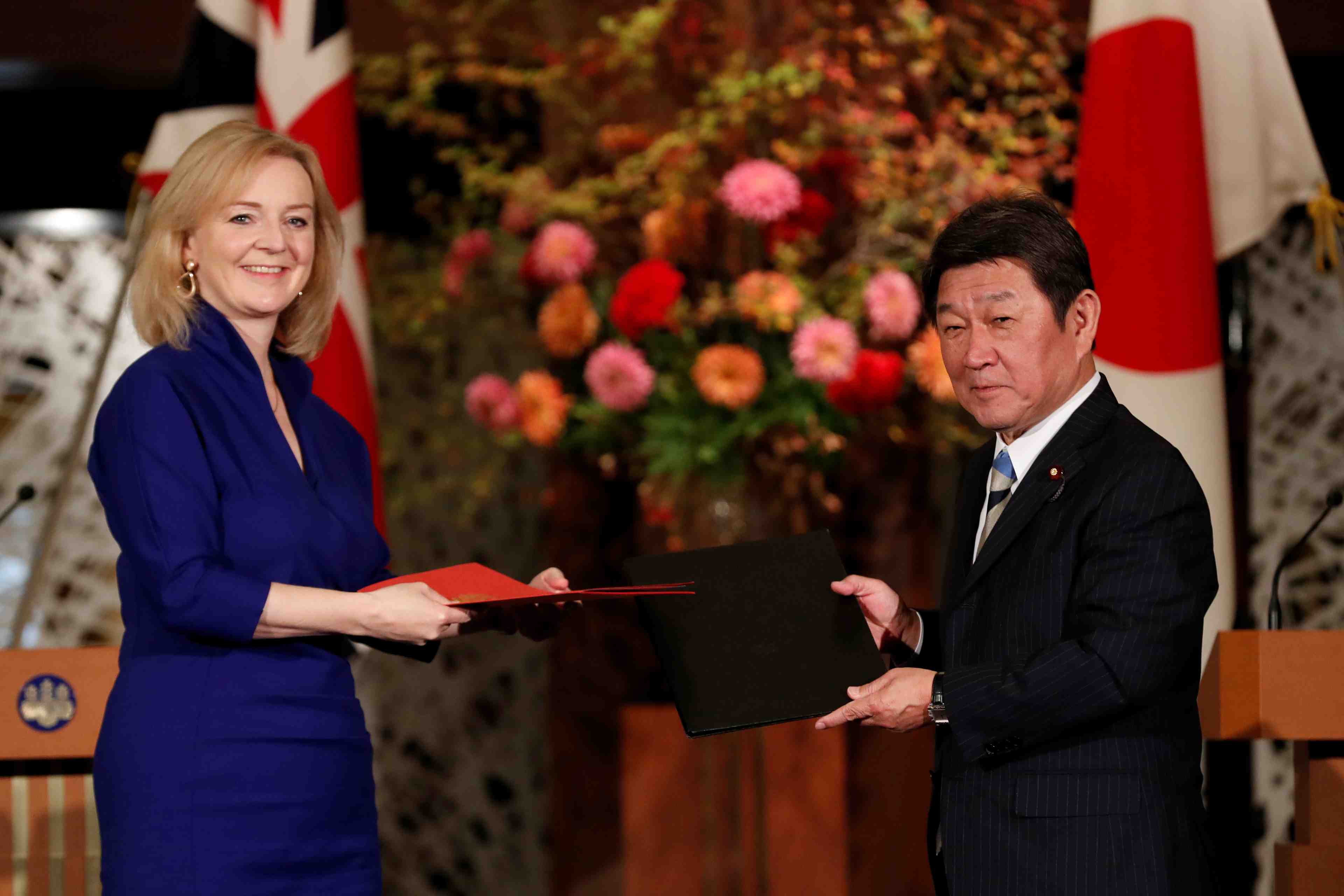 Britain's international trade secretary elizabeth truss and japanese foreign minister toshimitsu motegi sign the uk-japan comprehensive economic partnership agreement in tokyo